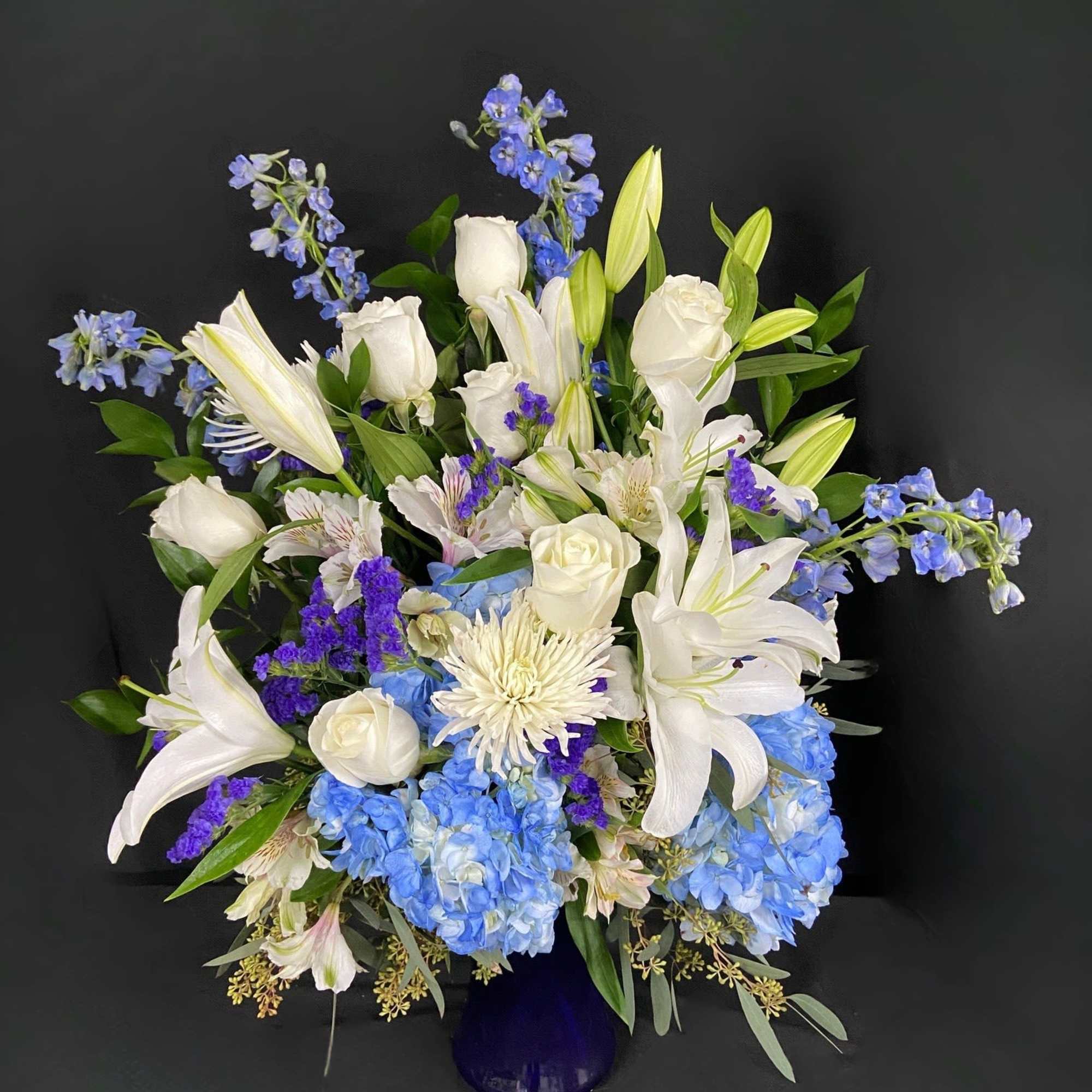 This peaceful arrangement includes roses, oriental lilies, fuji mums, blue delphinium, blue, photo 2 of 3