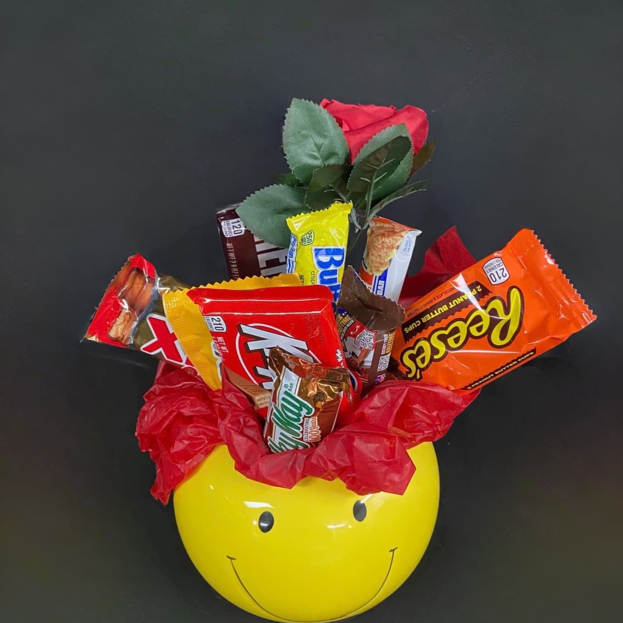 Candy bouquet in a yellow smiley-face container with a red rose