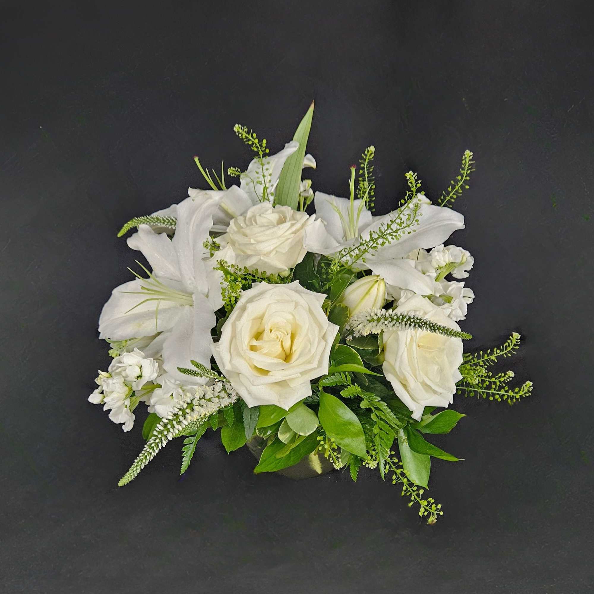 This arrangement includes white roses, white lilies, white stock, and dusty miller., photo 3 of 4