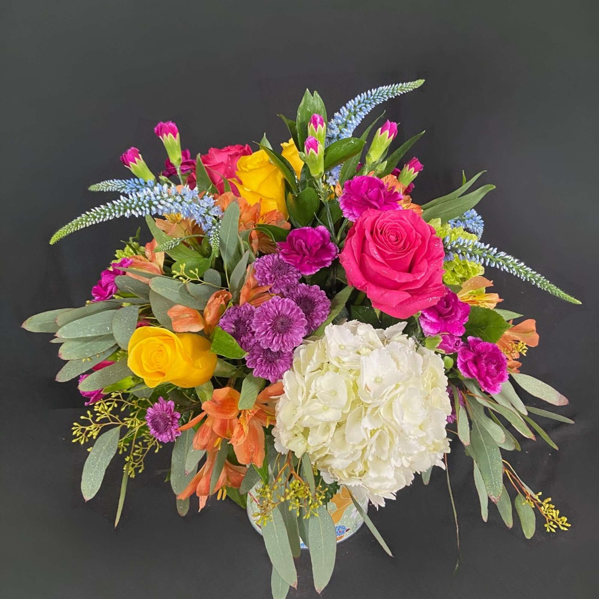 Mixed bouquet with pink, yellow, white, and purple flowers in a vase