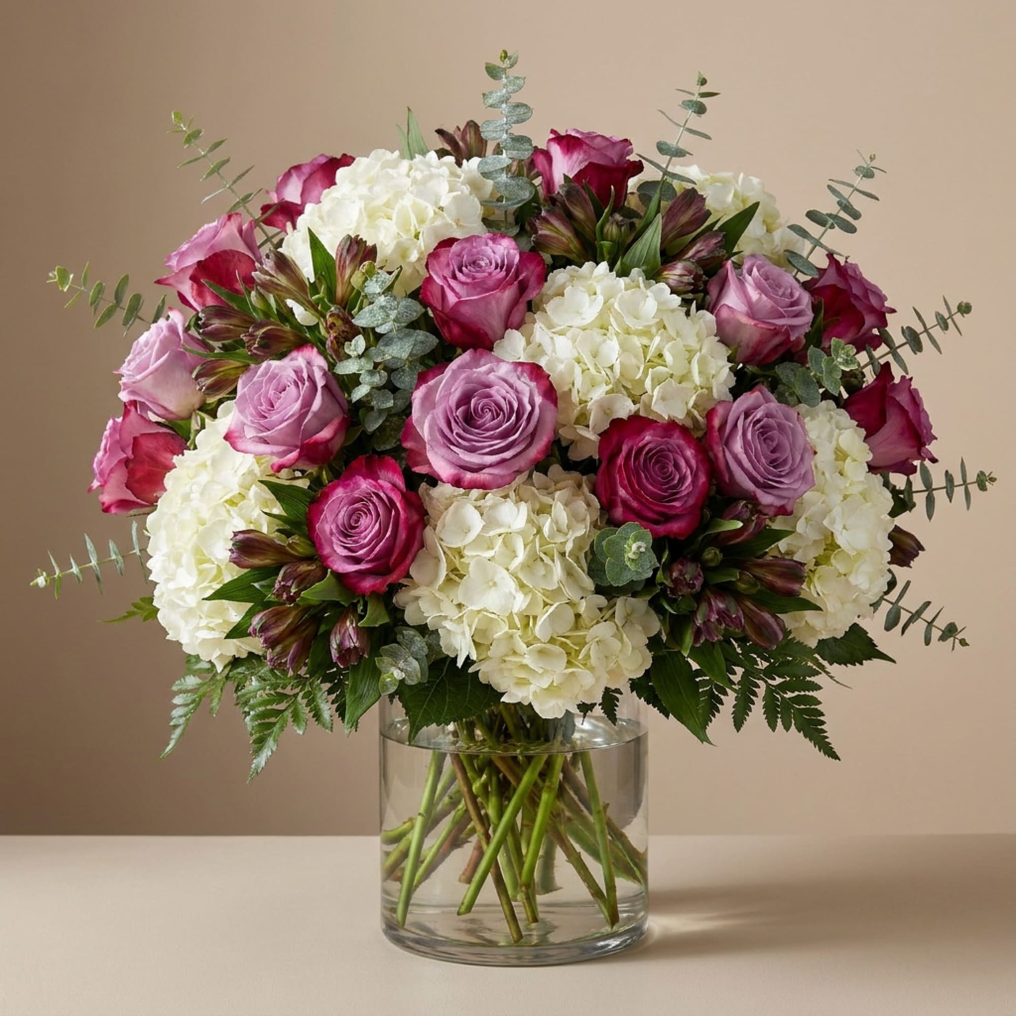 Bouquet of pink roses and white hydrangeas in a clear glass vase