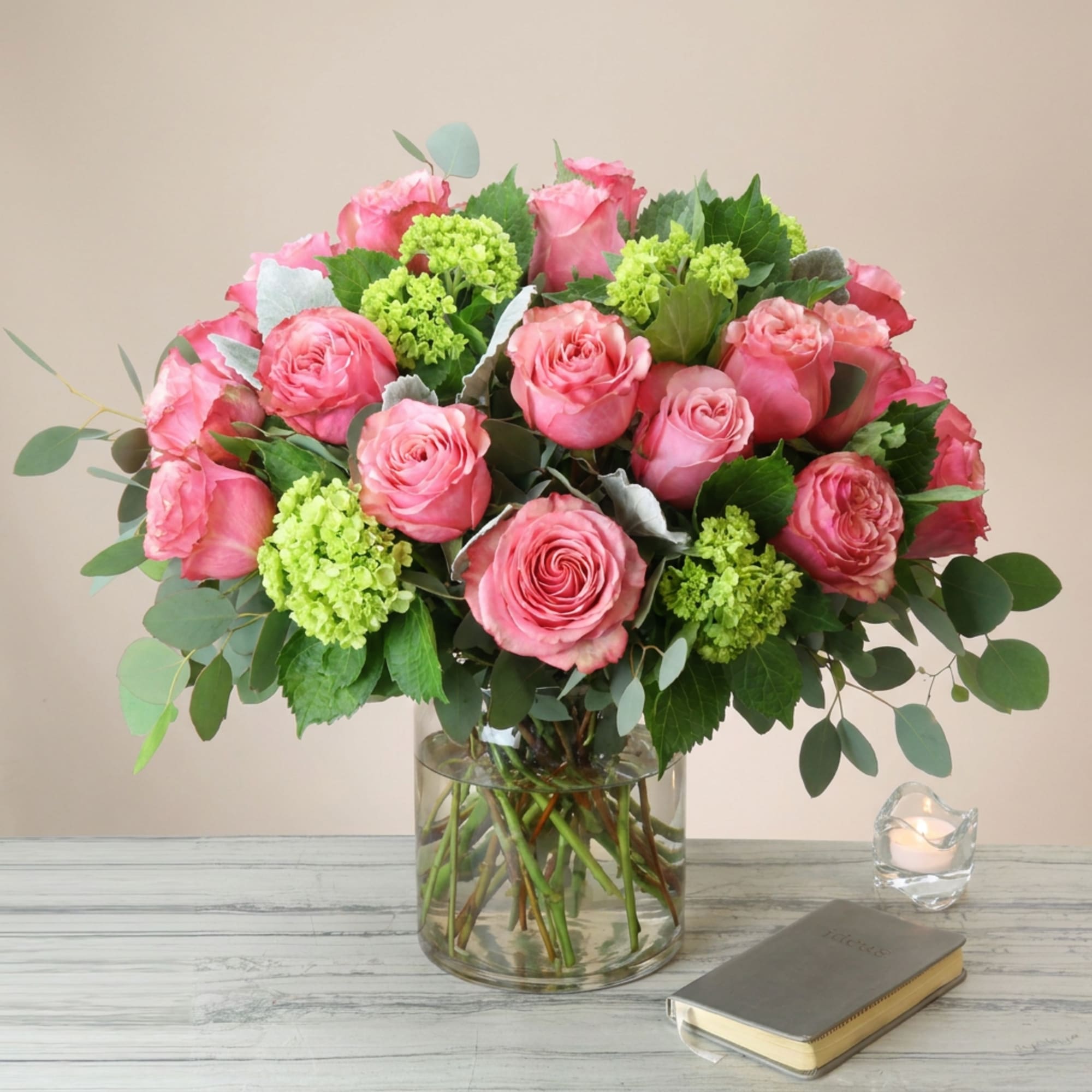 Pink roses and green hydrangeas in a clear glass vase
