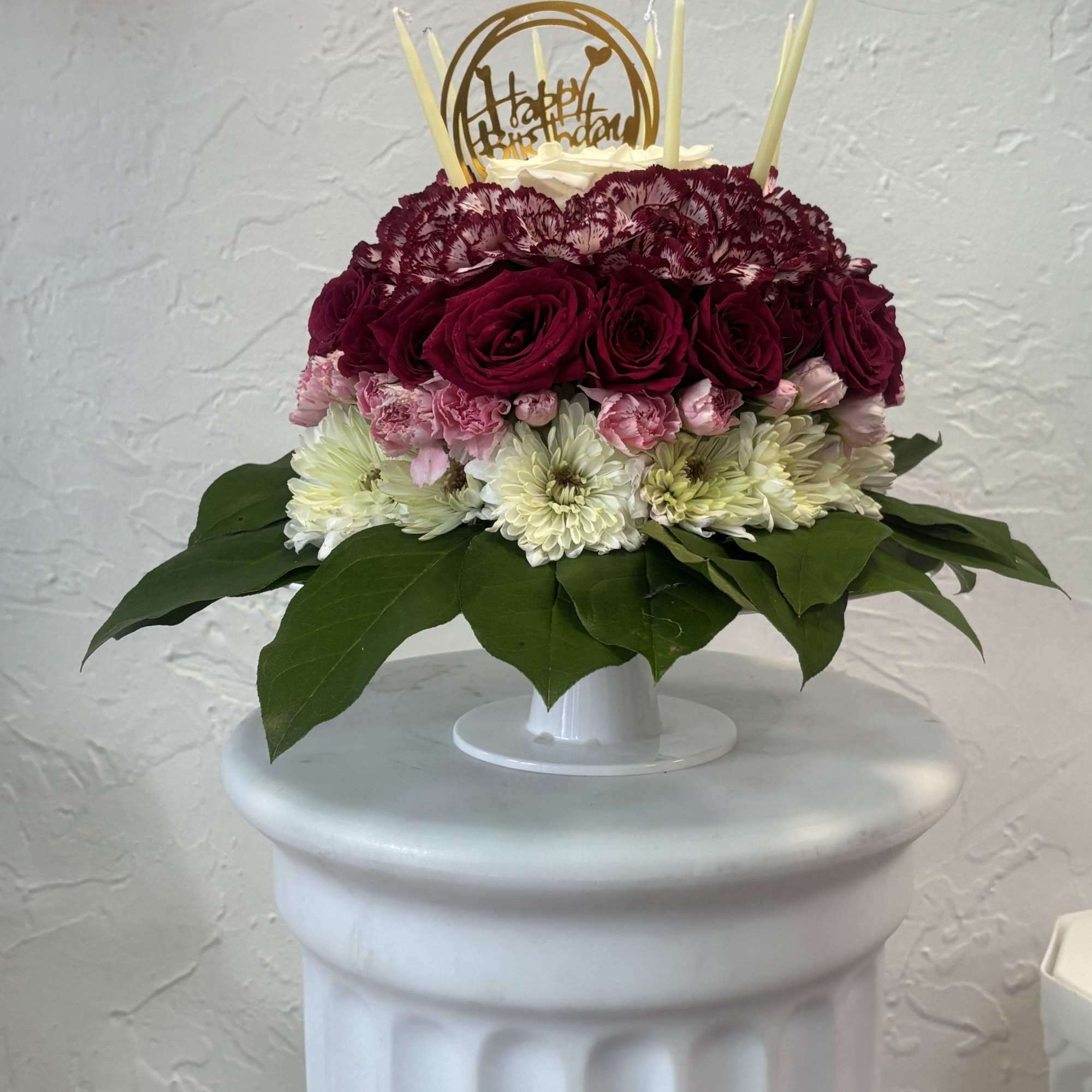 Celebrate a birthday with a delightful "Blooming Birthday Cake" floral arrangement adorned