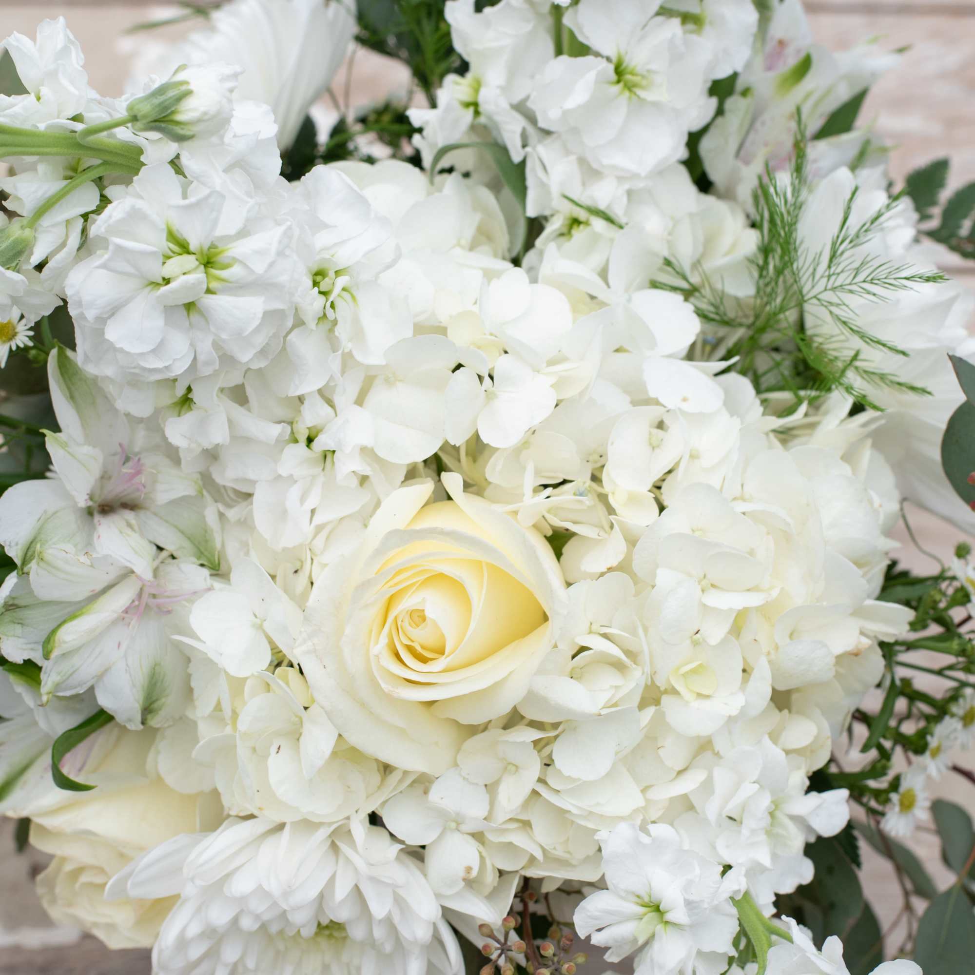 White floral bouquet with a pale yellow rose center