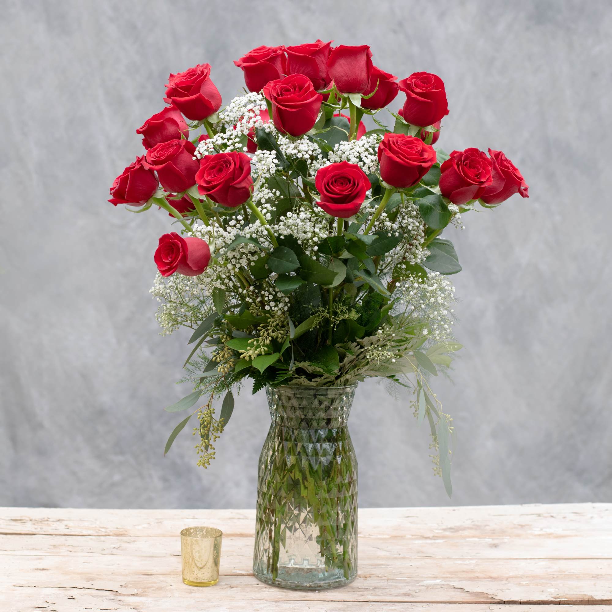 Bouquet of red roses with baby's breath in a glass vase