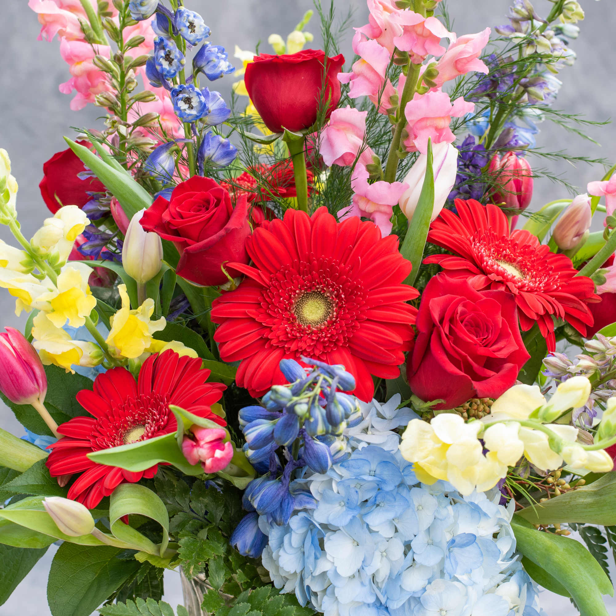 Colorful bouquet with red gerbera daisies, roses, hydrangea, and snapdragons