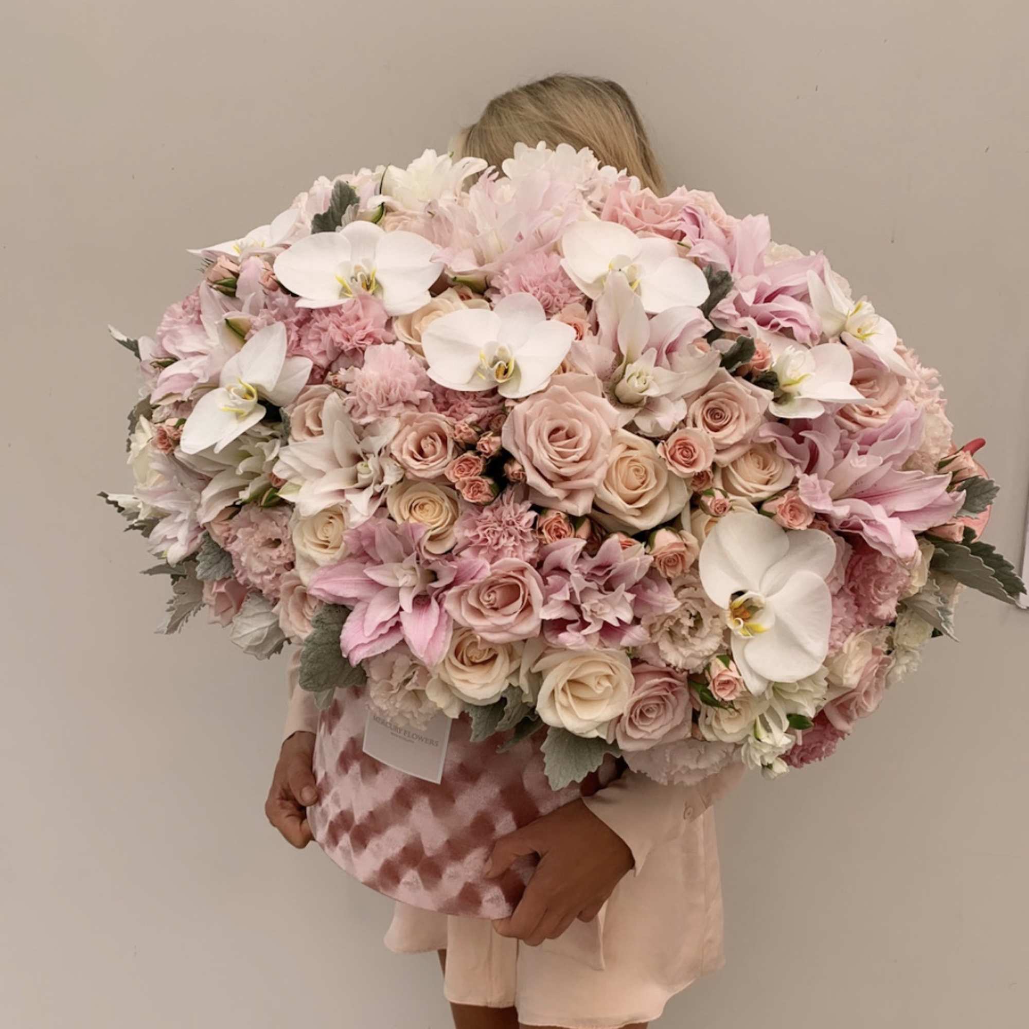 Large pastel bouquet of pink and white roses with orchids