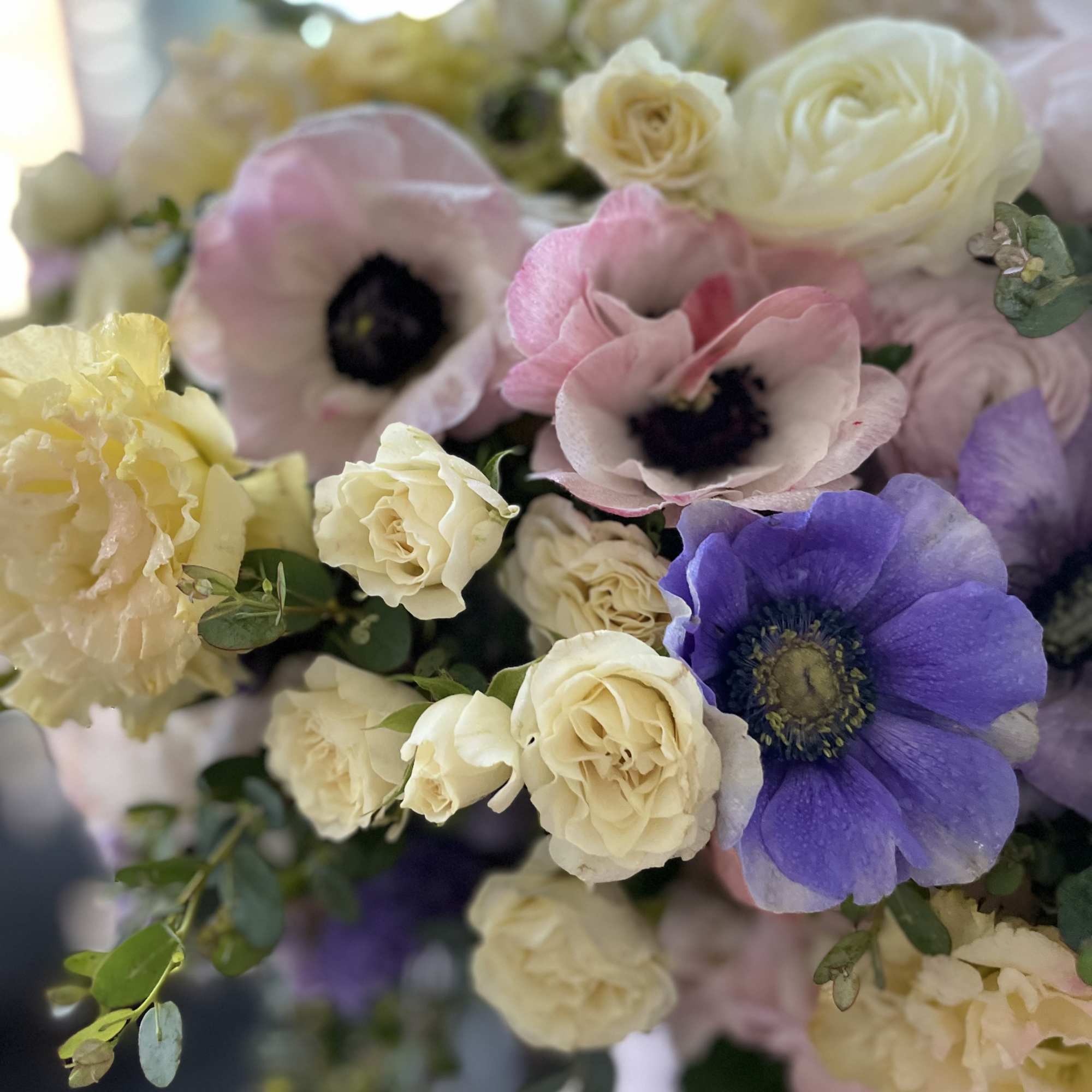 Pastel bouquet with pink and purple blooms and cream roses