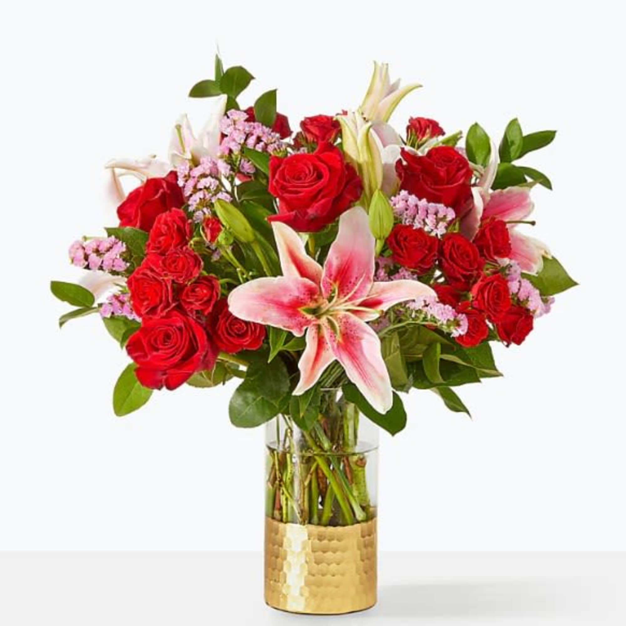 Bouquet of red roses and pink lilies in a glass vase