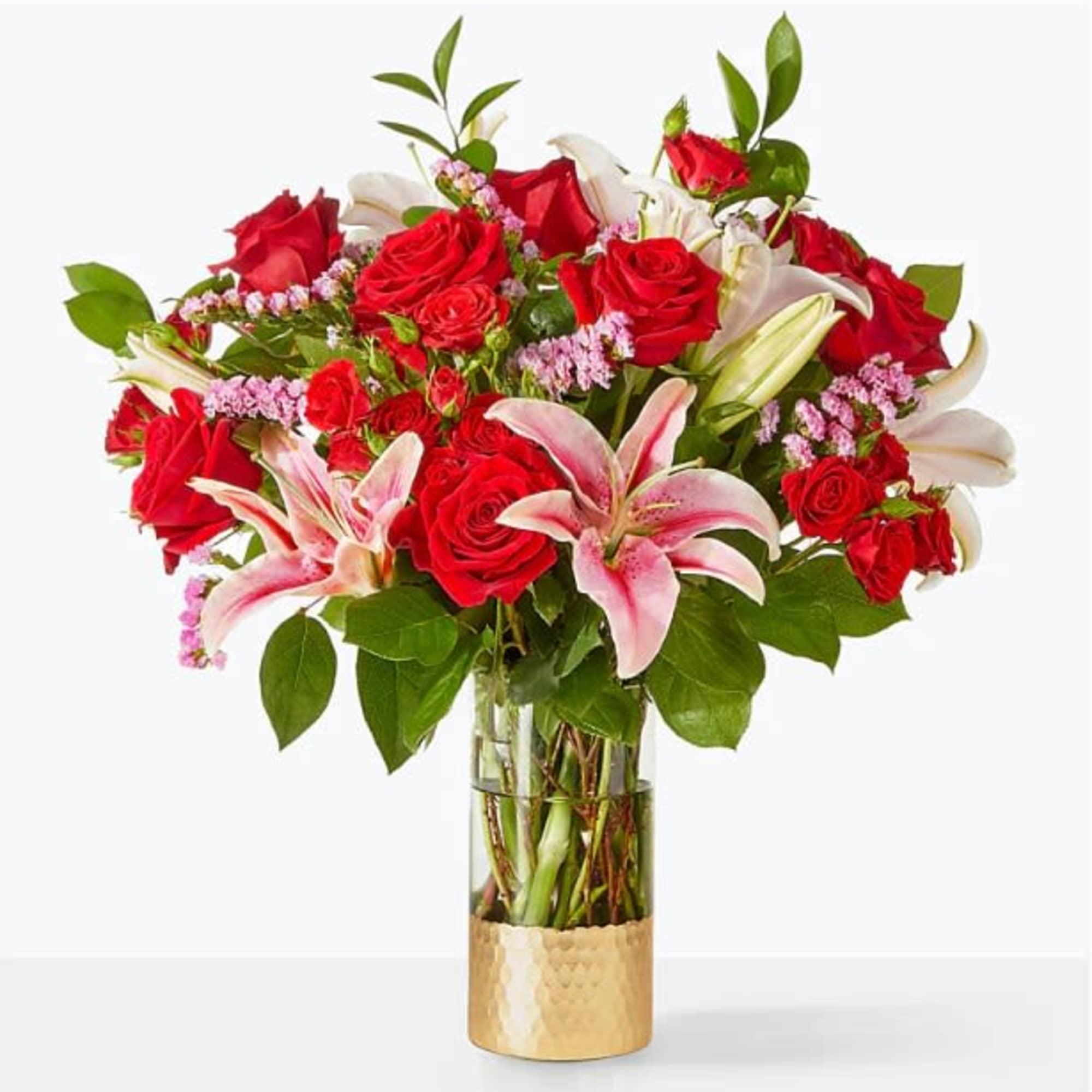 Bouquet of red roses and pink lilies in a glass vase
