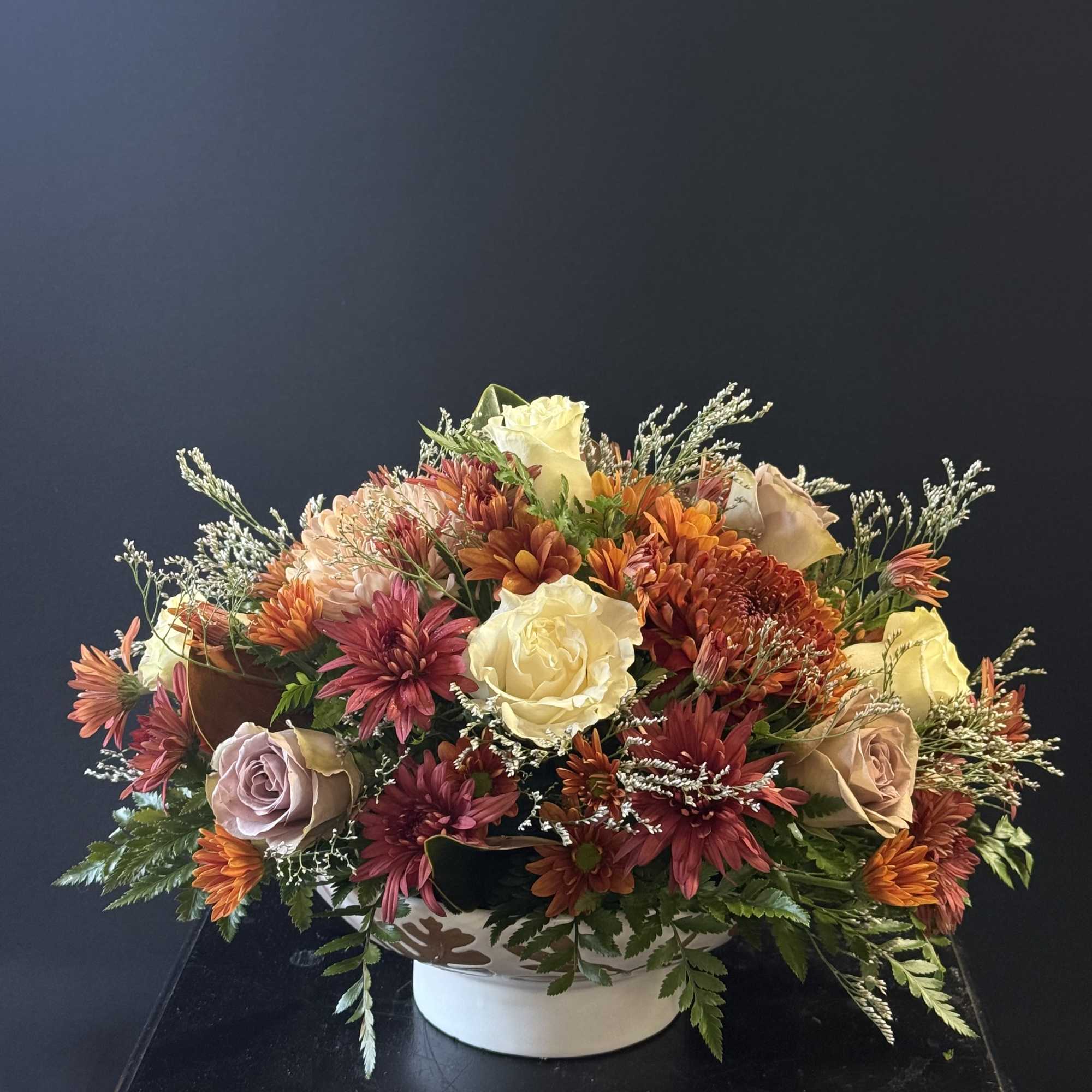 An inviting arrangement filled with blooms in spiced tones, perfect for setting