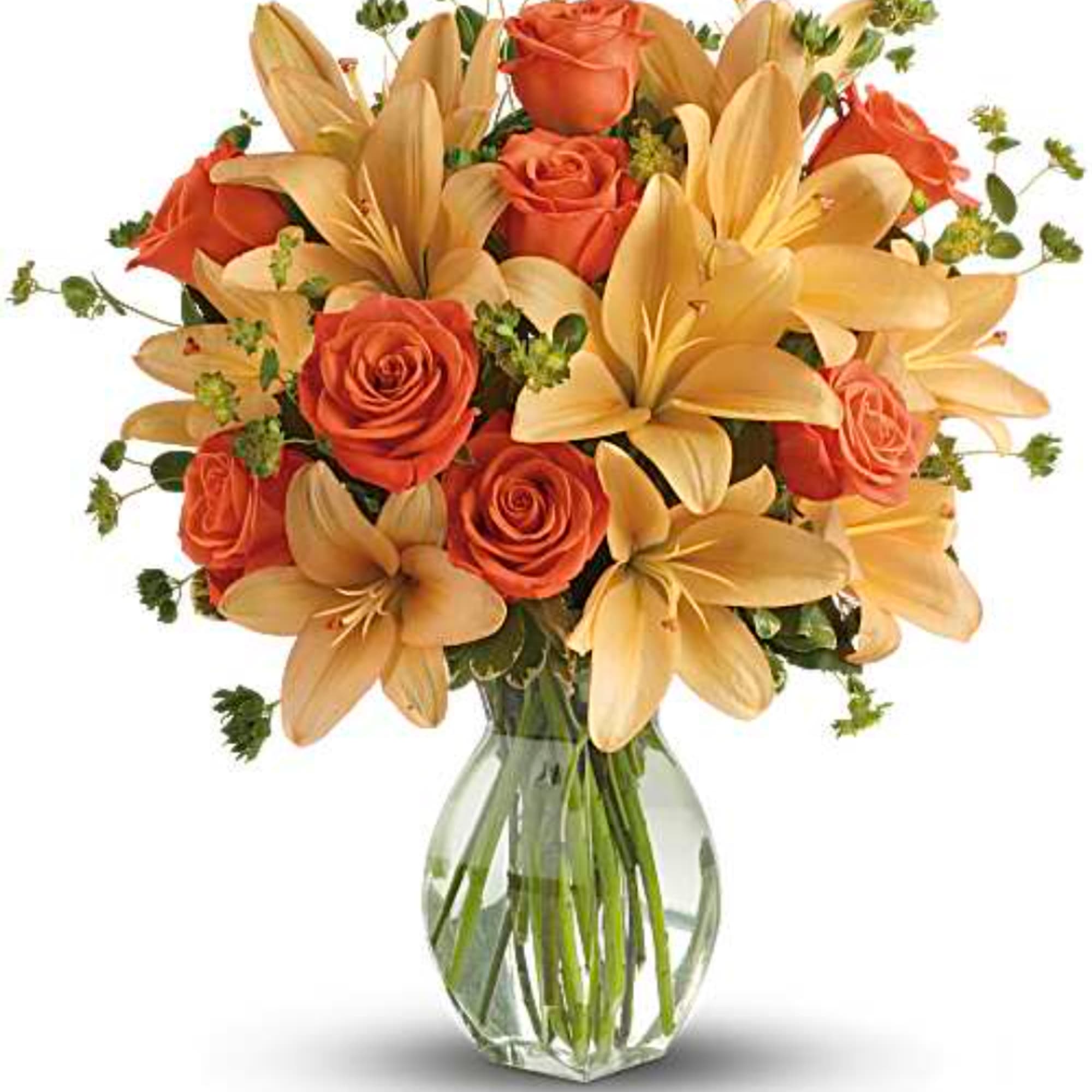 Orange roses and pale lilies arranged in a clear glass vase