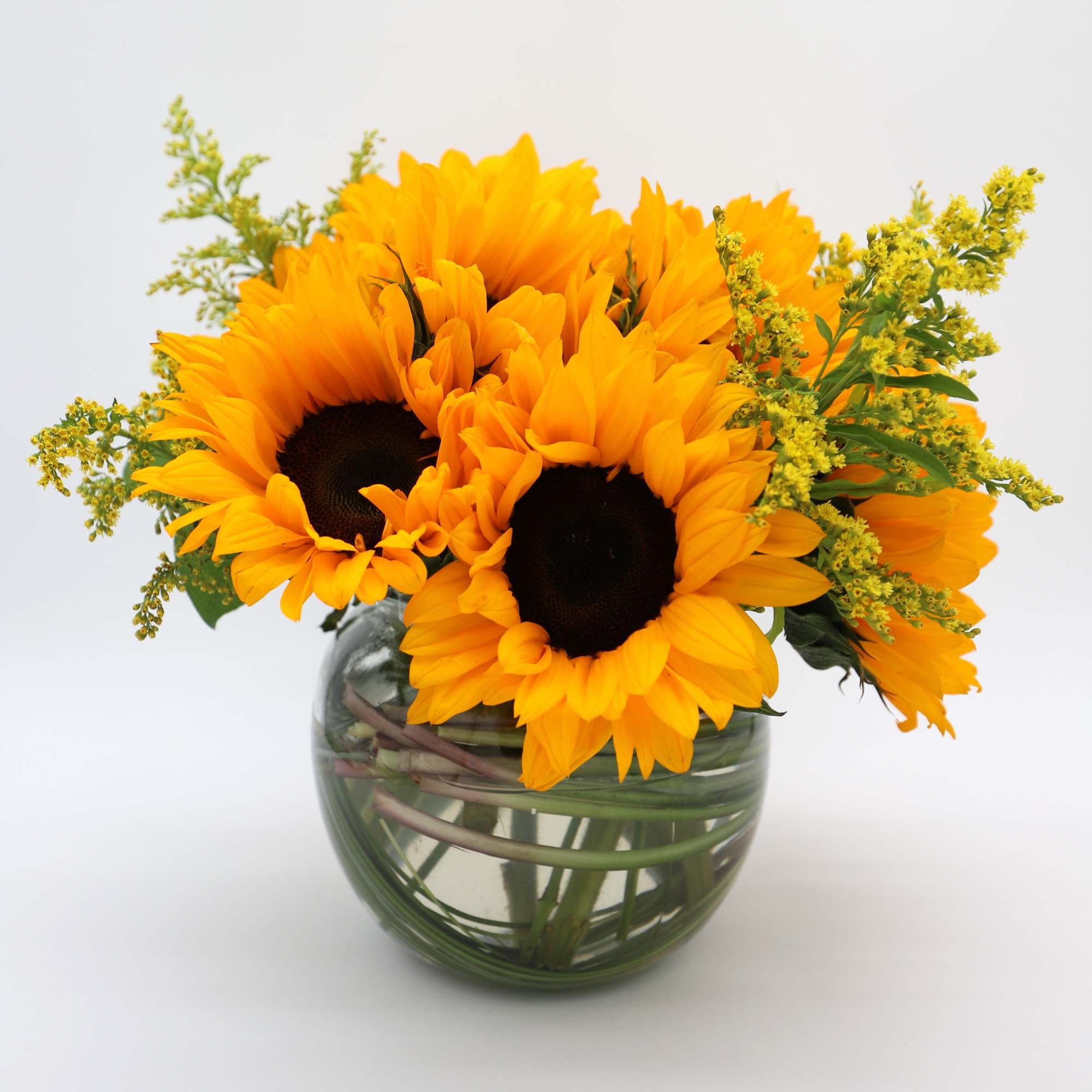 The most sunny arrangement full of Sunflowers and Solidago in a glass