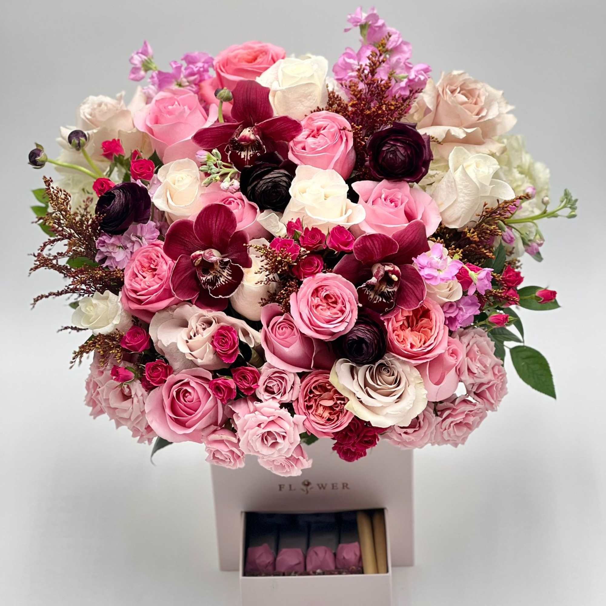 Pink and white rose bouquet with dark orchids in a gift box