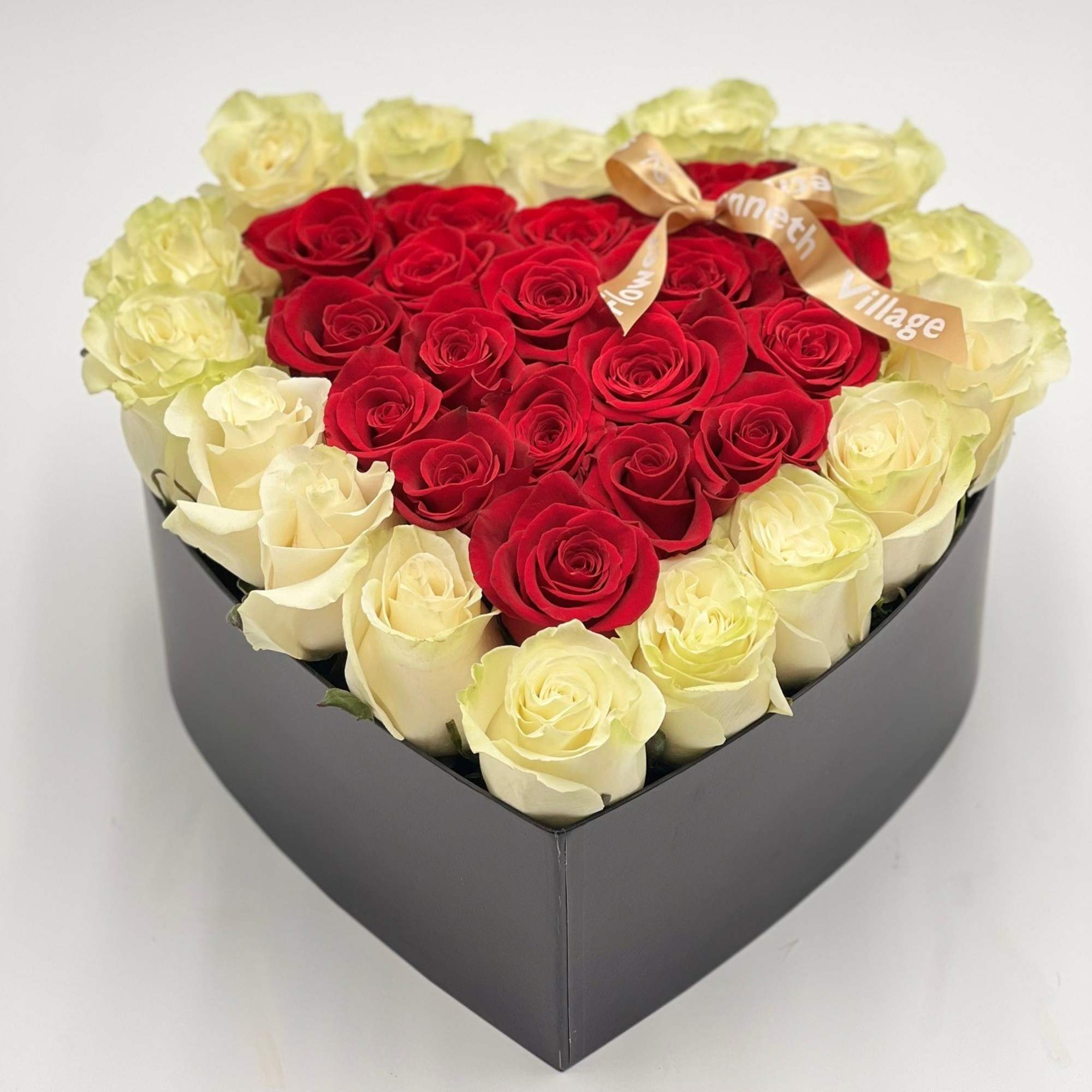 Heart-shaped box filled with red and cream roses