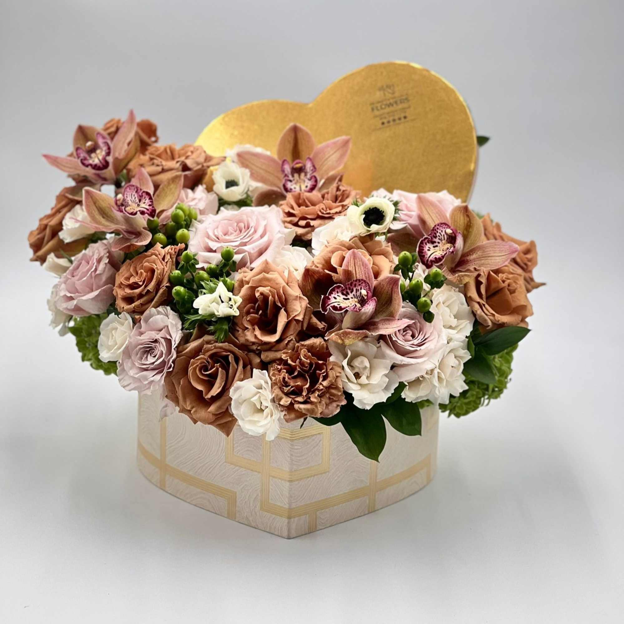 Heart-shaped flower box with pink and tan roses and orchids