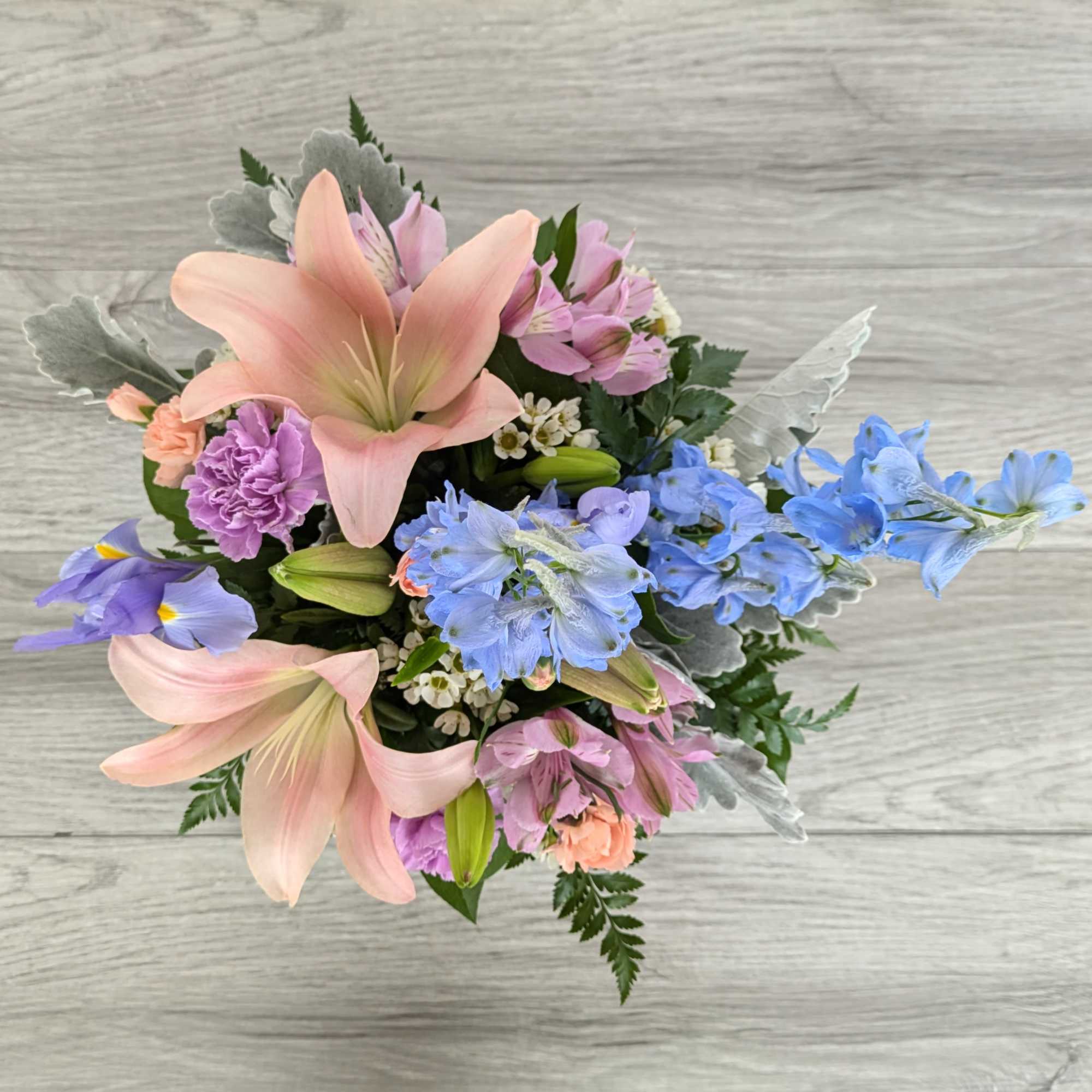 Pastel bouquet with lilies, blue delphinium, and pink alstroemeria