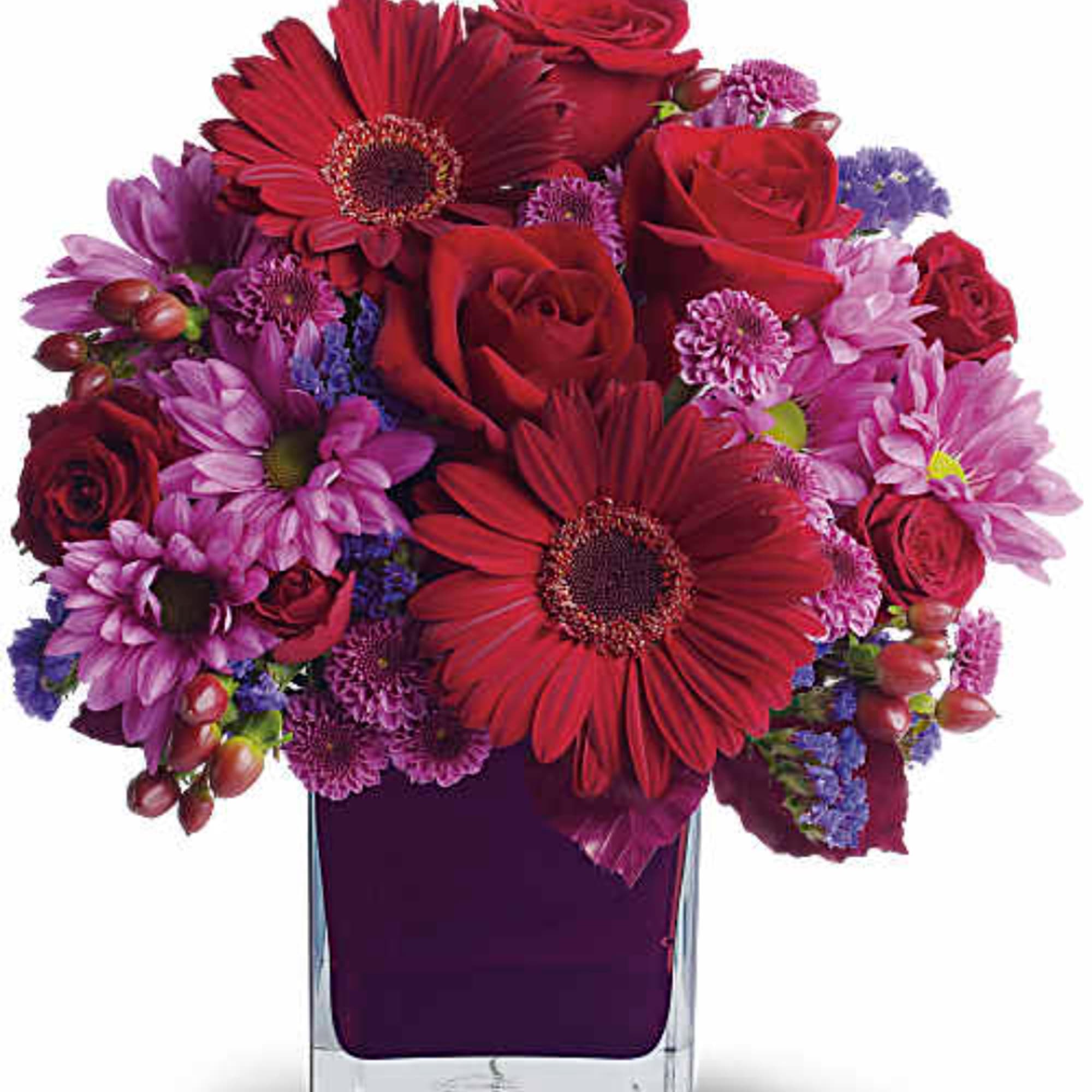 Red and purple mixed bouquet in a clear square vase