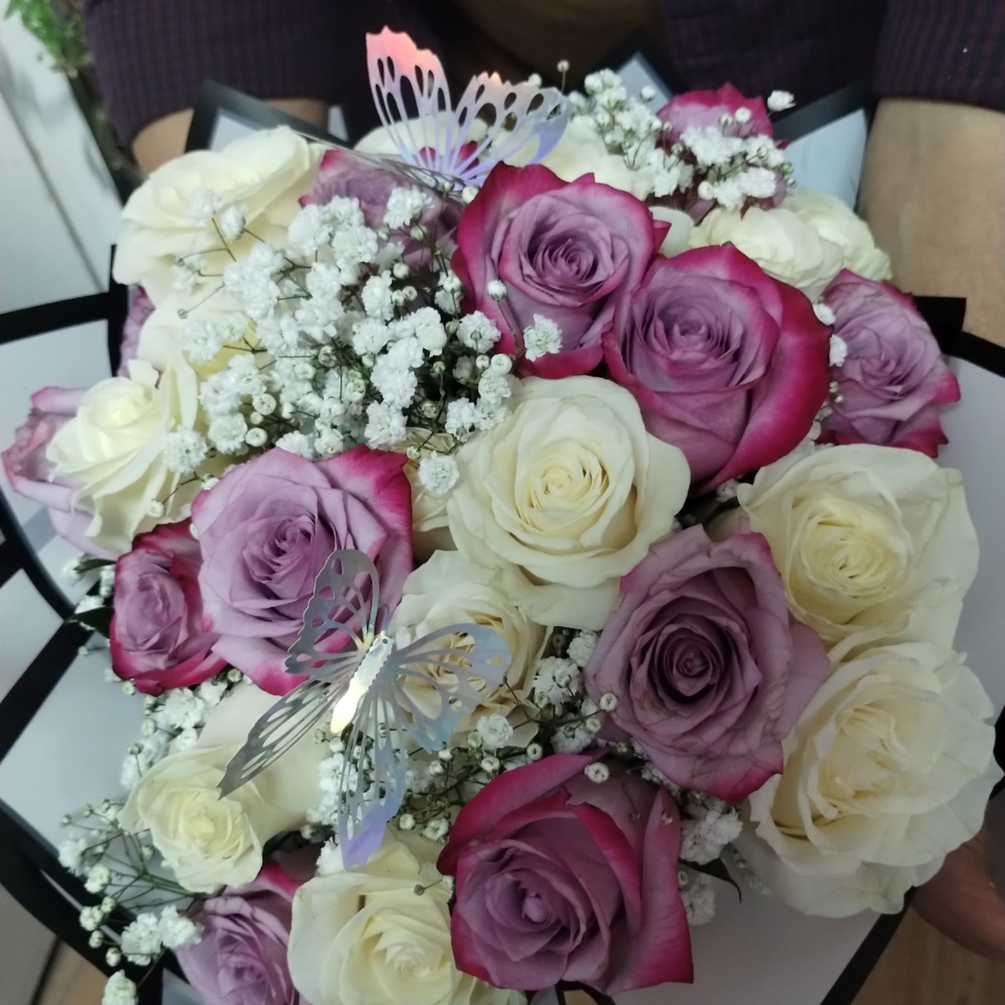 Bouquet of pink, lavender, and white roses with baby’s breath