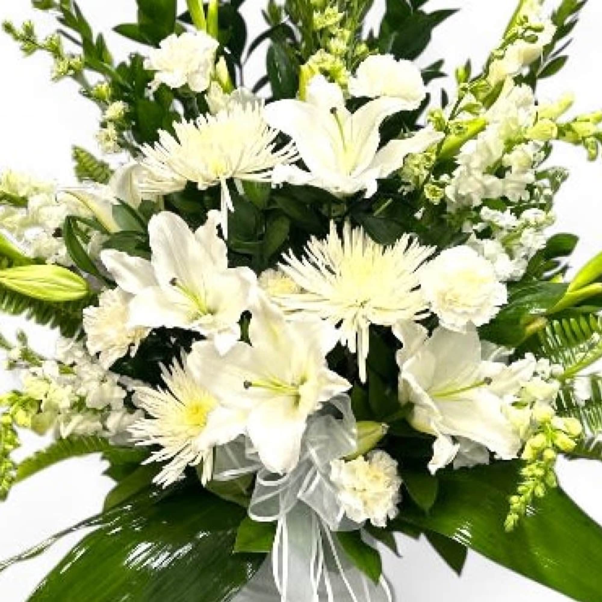 White lilies and spider mums in a bouquet with green foliage