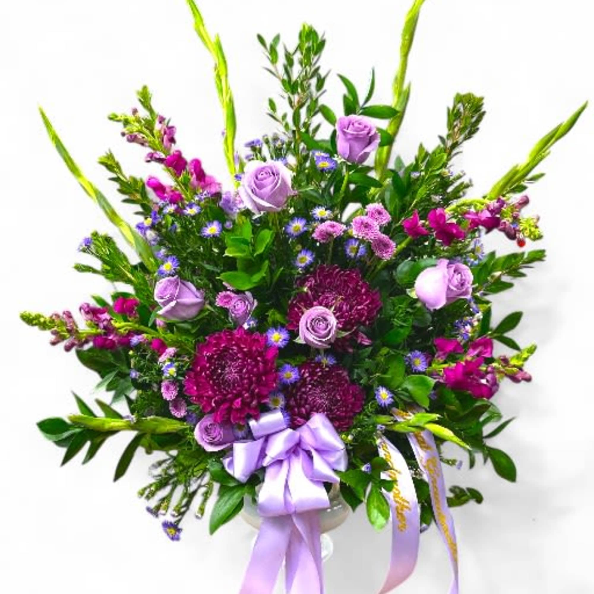 Lavender and magenta floral spray with ribbon on a white background