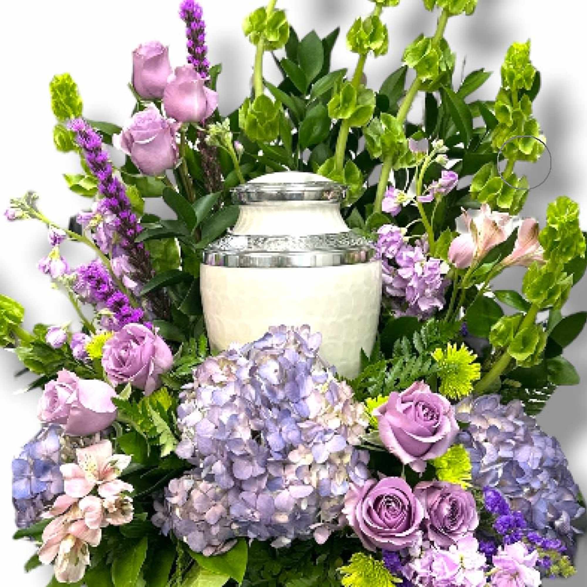 Lavender roses and hydrangeas arranged around a white urn