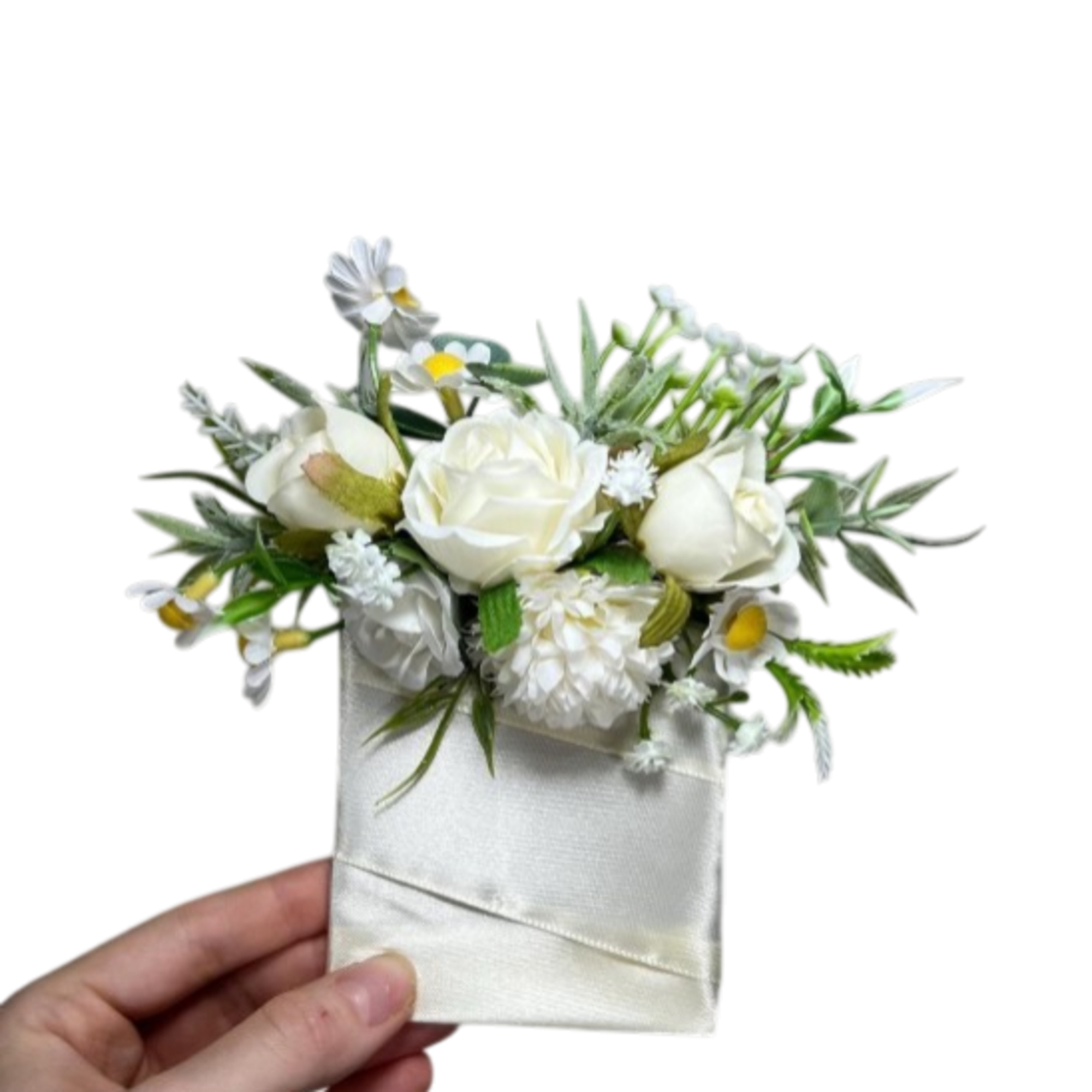 Small white floral corsage with ribbon wrap held in a hand