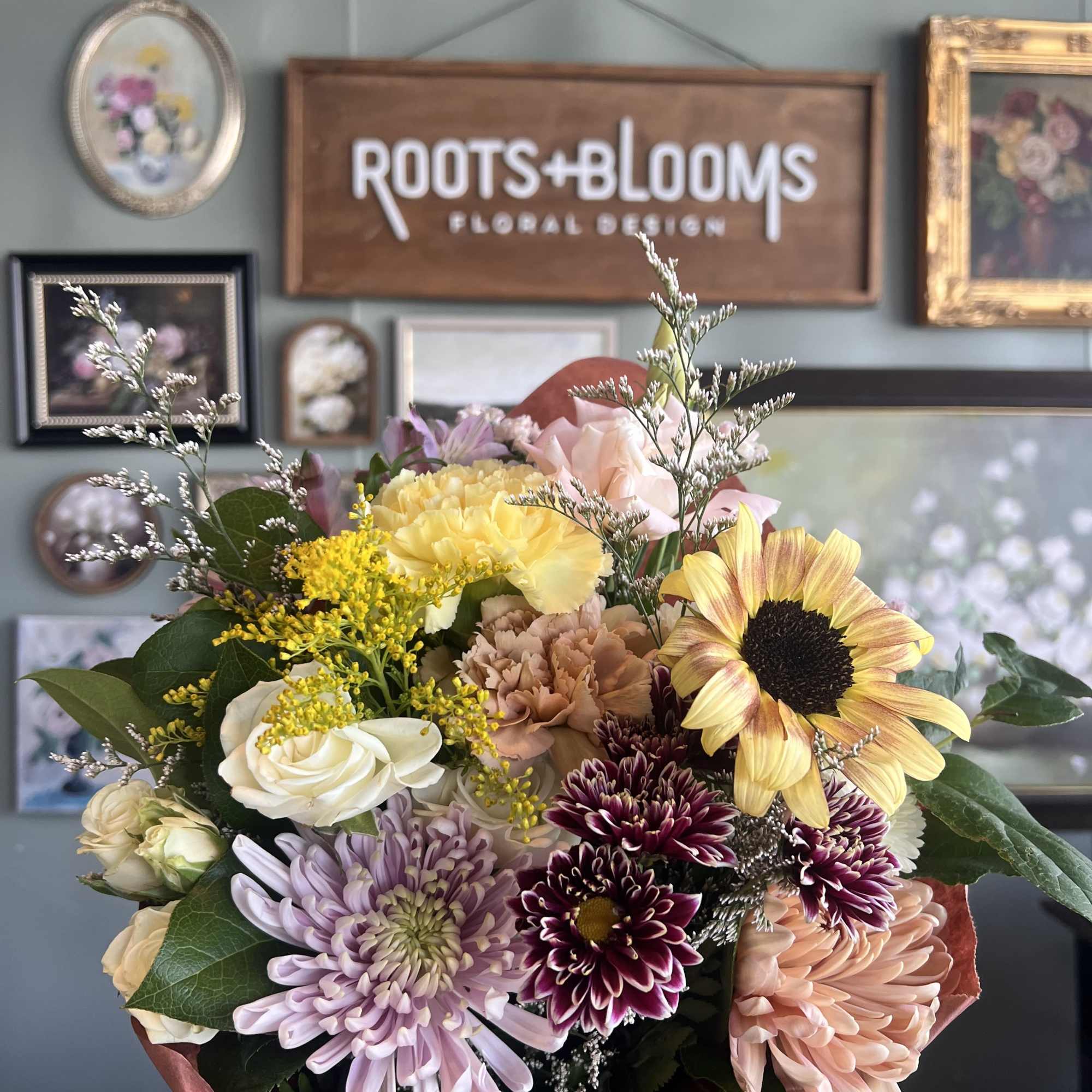 Mixed bouquet with sunflowers, roses, and chrysanthemums wrapped in paper