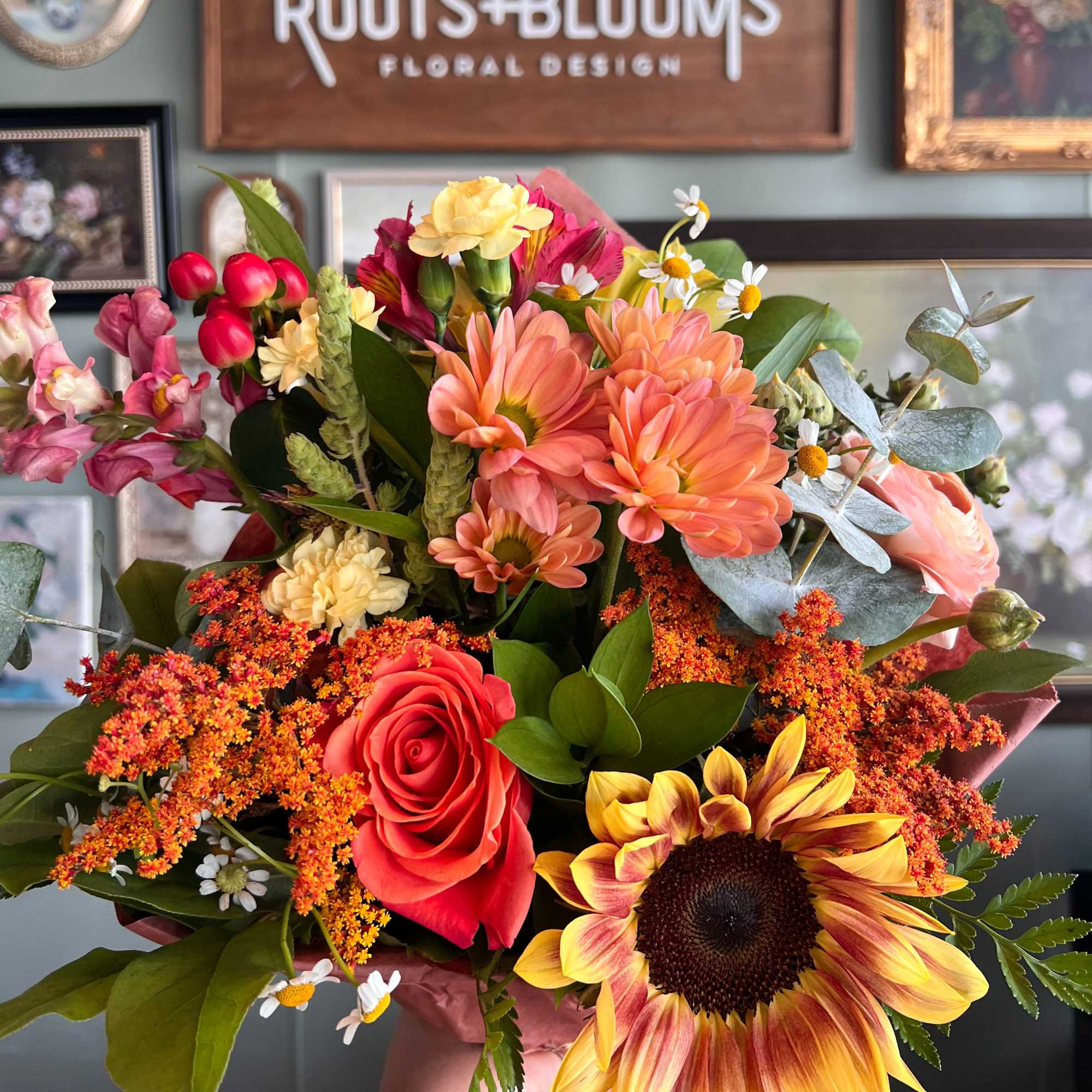 Mixed bouquet with sunflowers, roses, and orange daisies