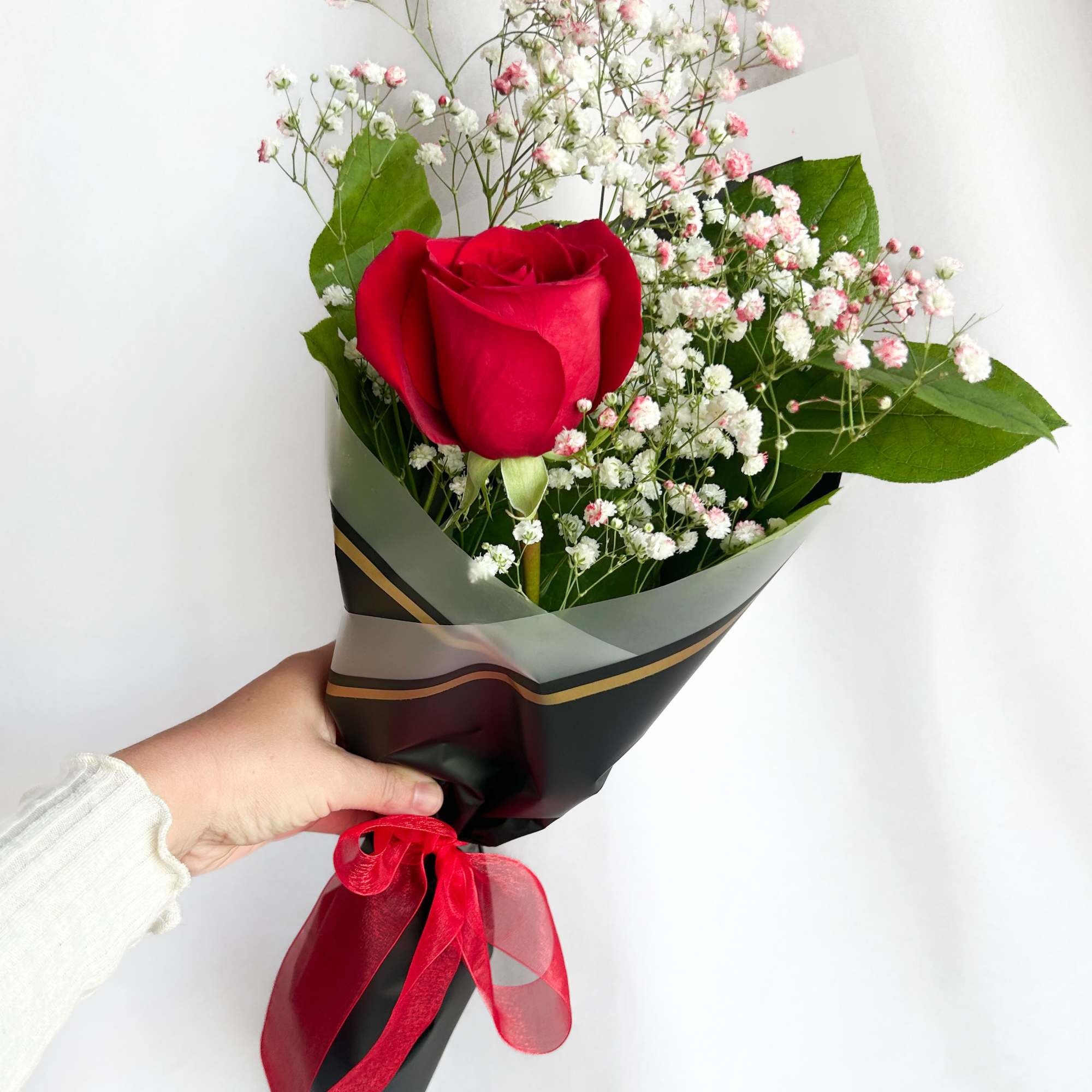 Single red rose bouquet with baby's breath in black wrap and red ribbon