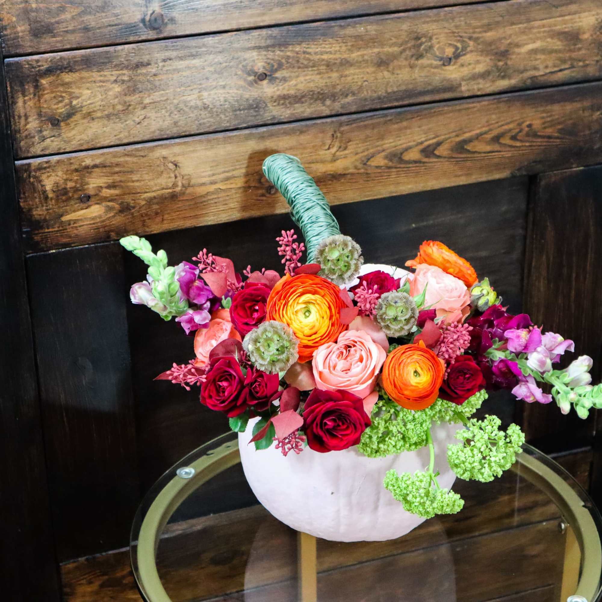 Colorful mixed flower arrangement in a white pumpkin-shaped container