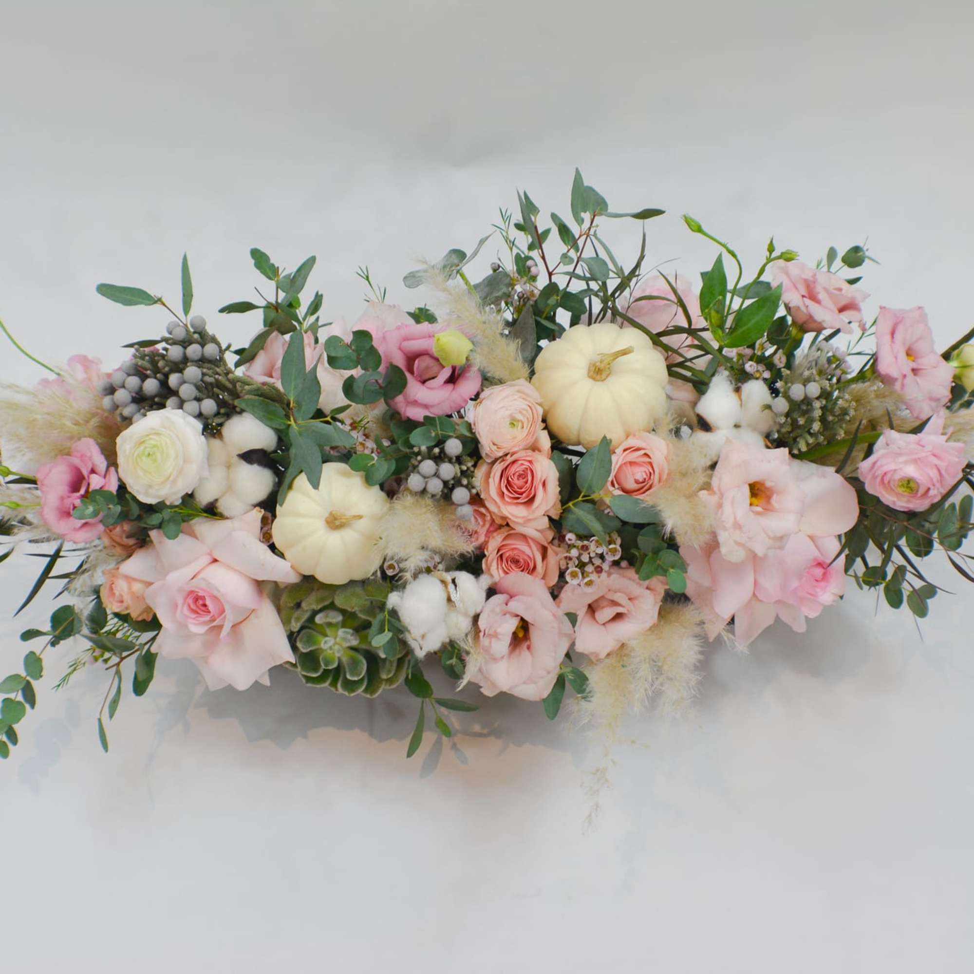Low pastel floral centerpiece with pink roses and white pumpkins