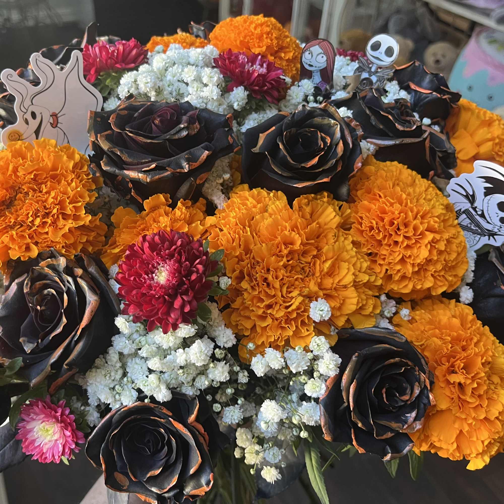 A dozen roses, marigolds, baby&rsquo;s breath, and asters With nightmare before Christmas