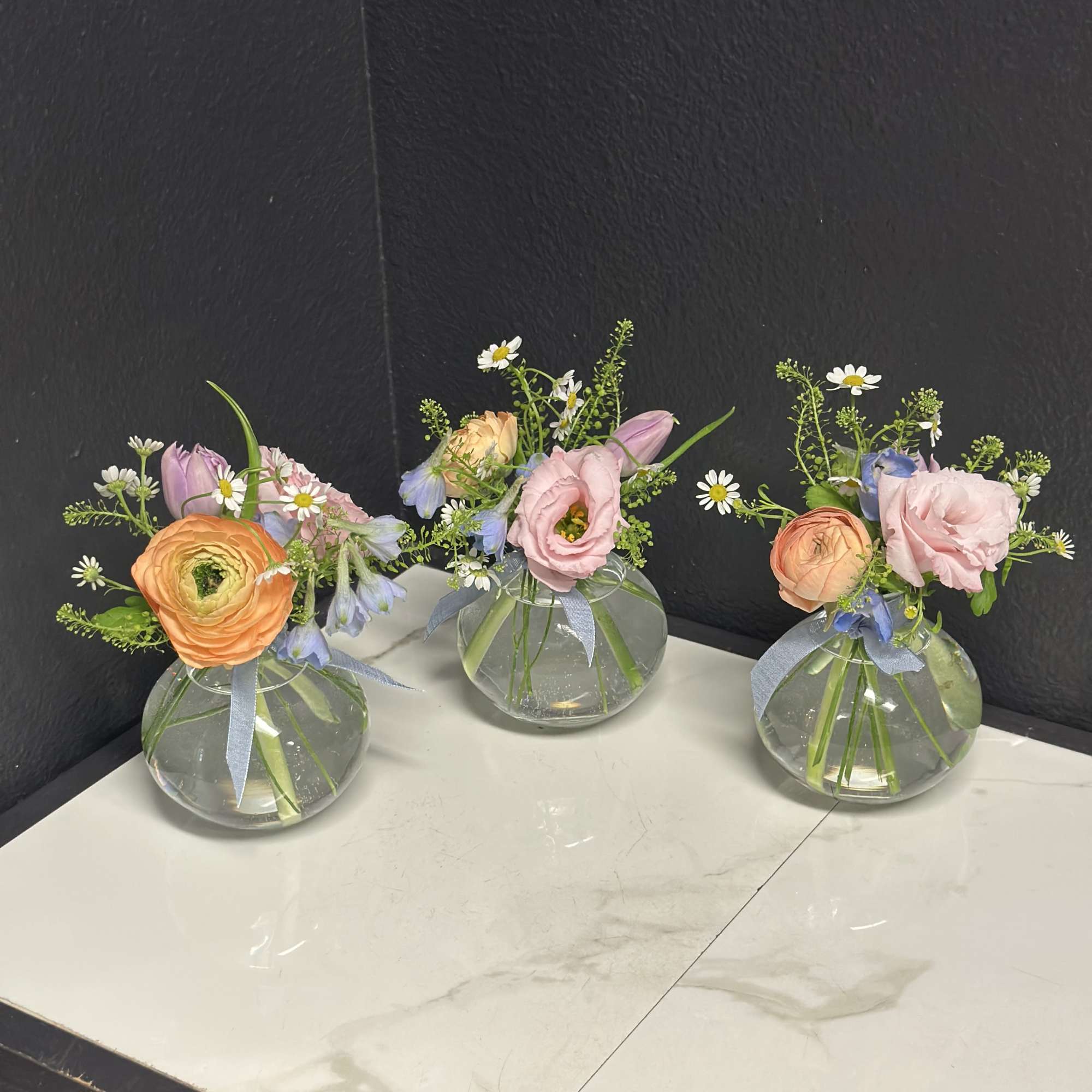 A trio of budvases filled with seasonal blooms in soft pastel shades., photo 3 of 3