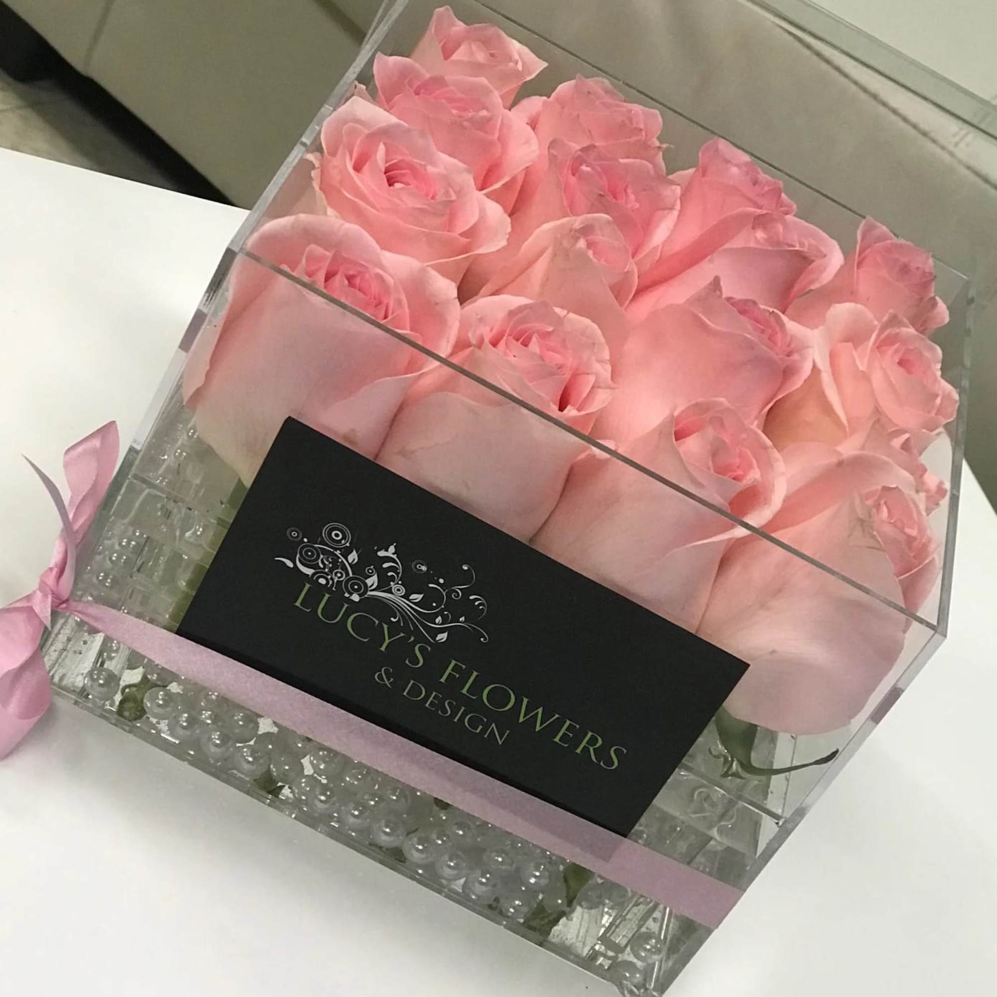 Box of pink roses with a pink ribbon