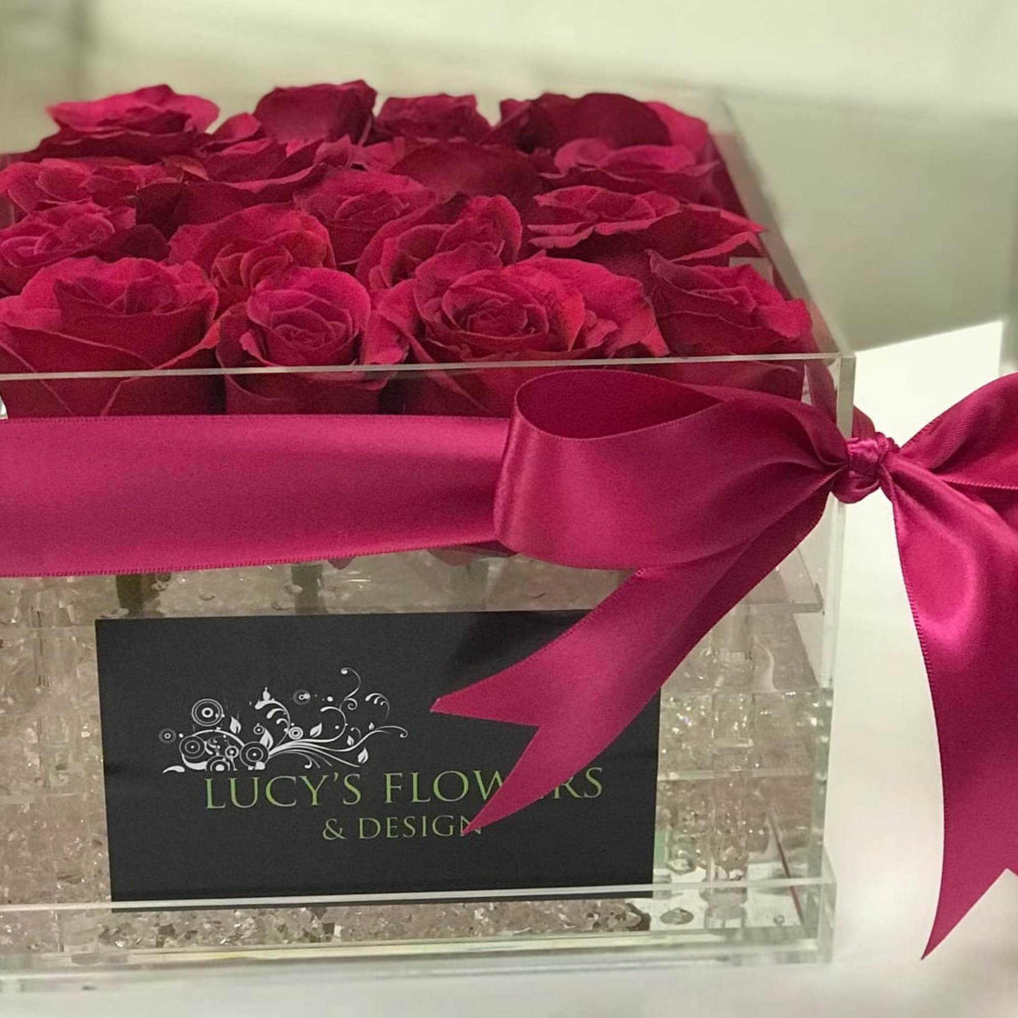 Box of deep pink roses tied with a satin ribbon