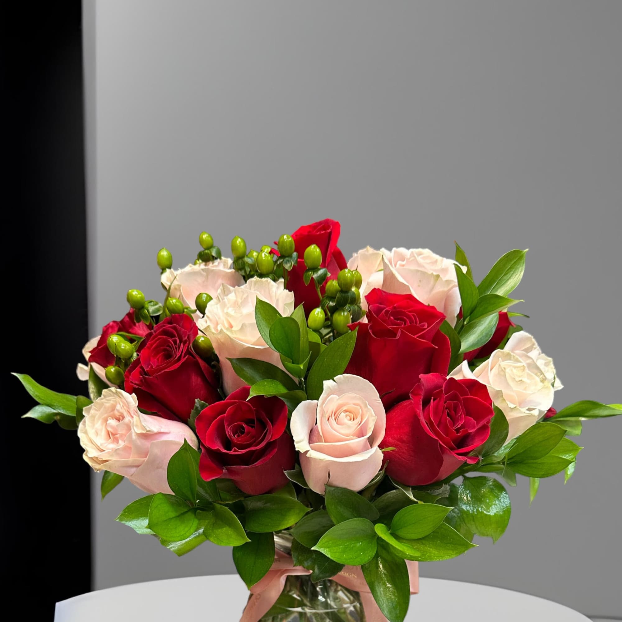 Bouquet of red and blush roses in a glass vase