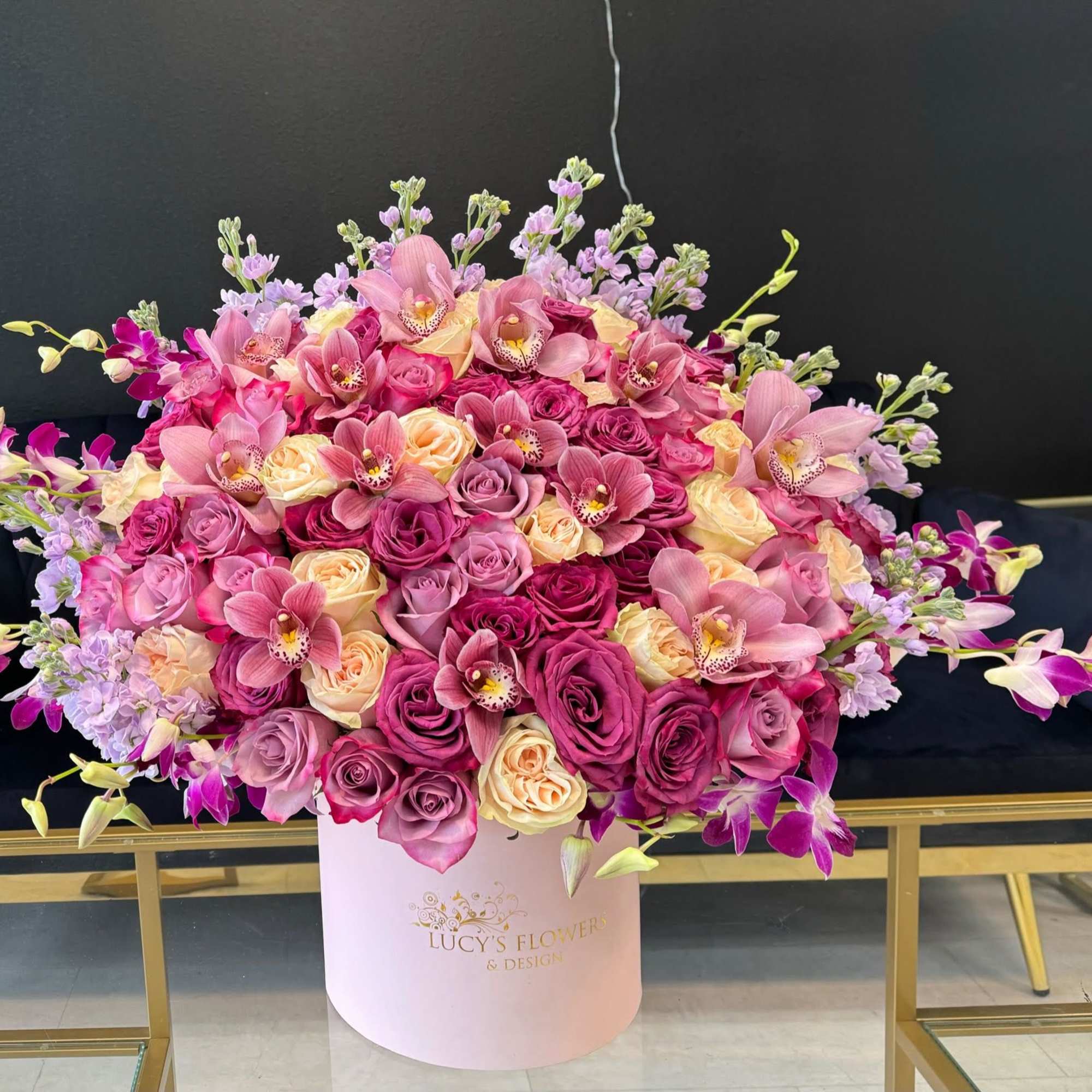 Large pink and purple floral arrangement in a pale pink box
