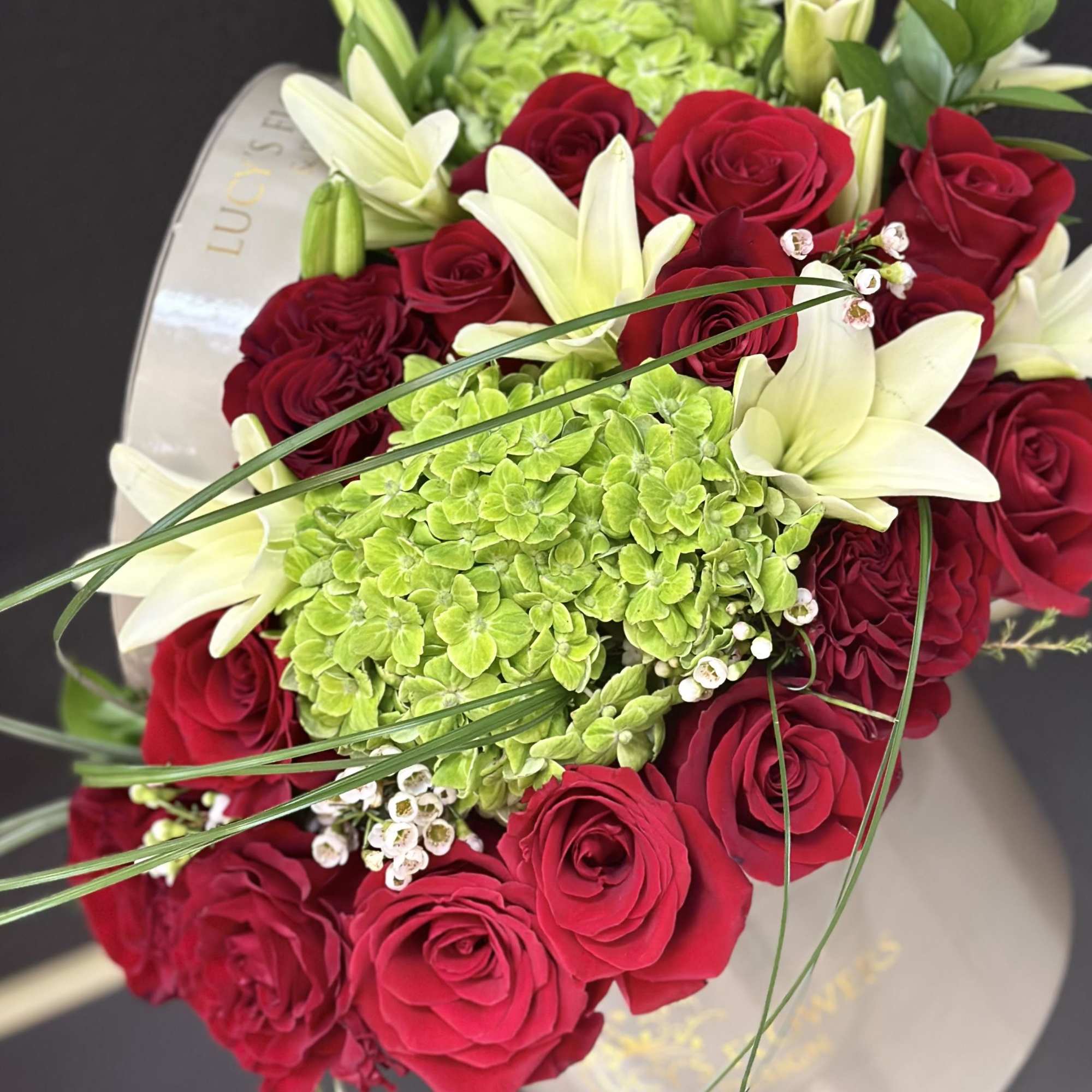 Bouquet of red roses and white lilies with green hydrangeas