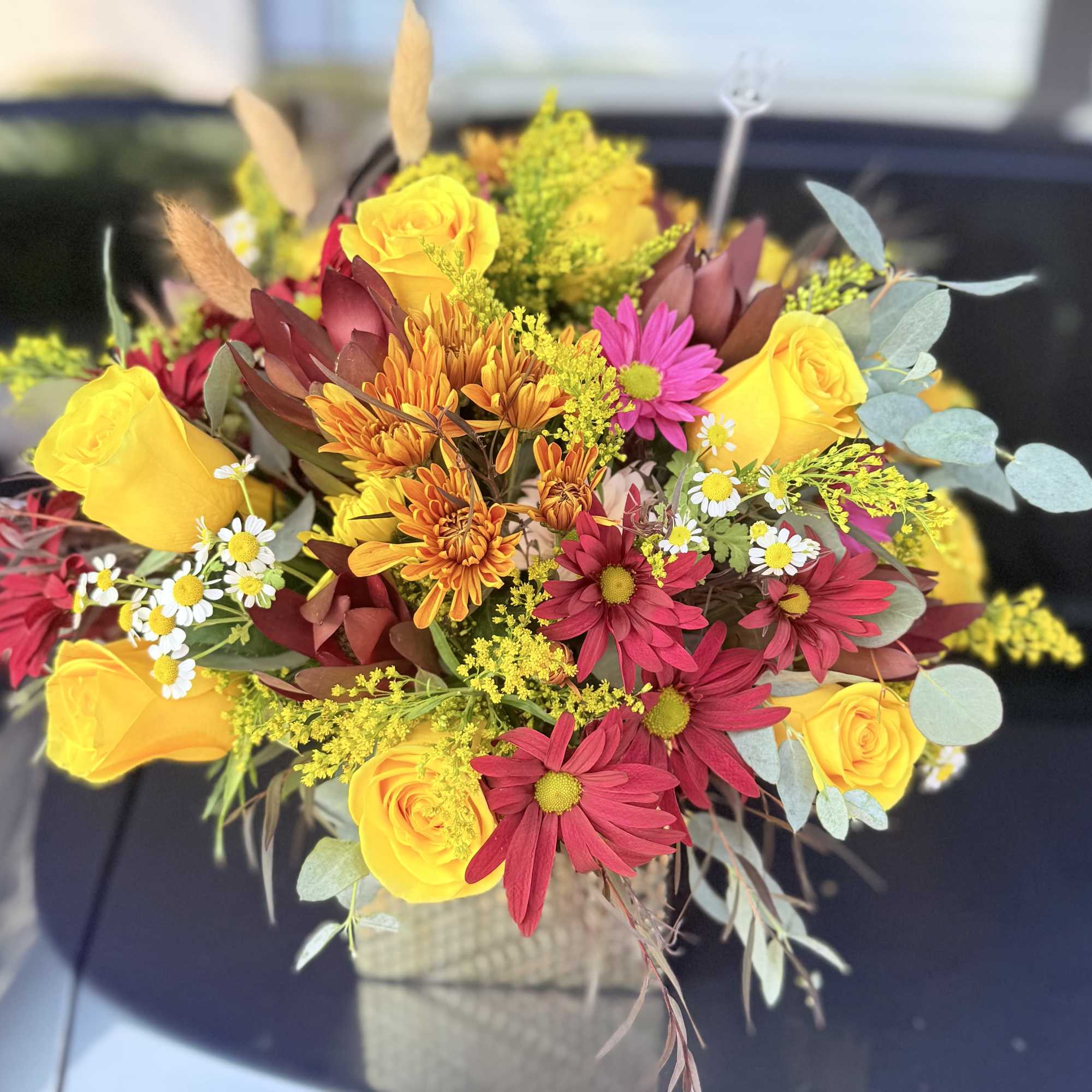 Bouquet of yellow roses and red daisies in a vase