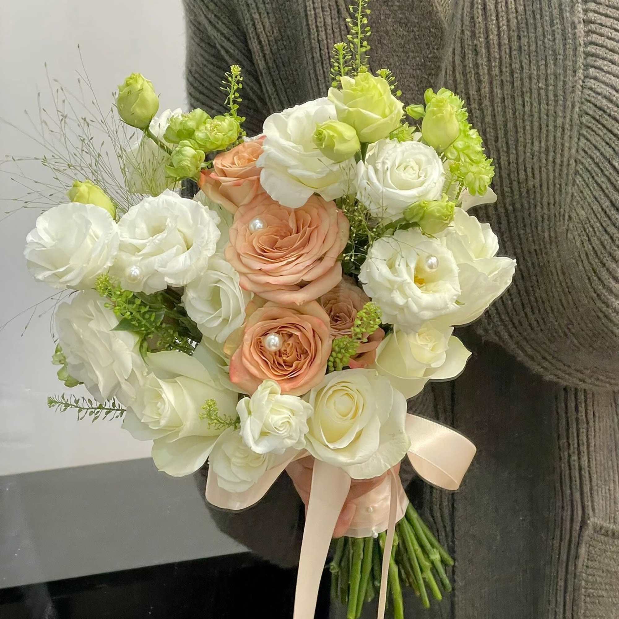 Bouquet of white and peach roses with a pale ribbon