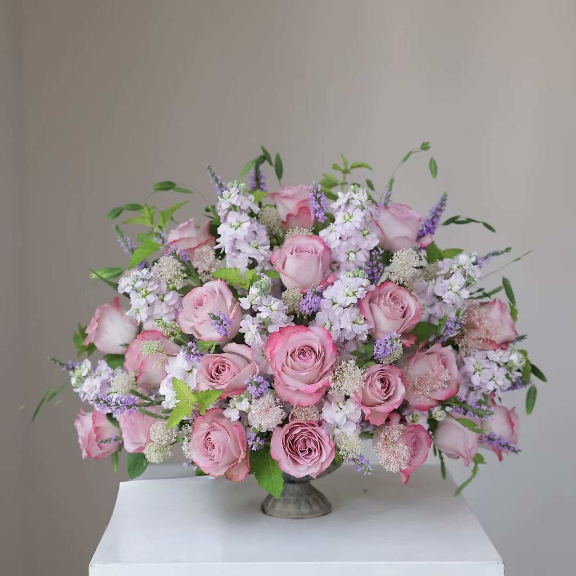 Pink rose bouquet with lavender filler flowers in a low vase