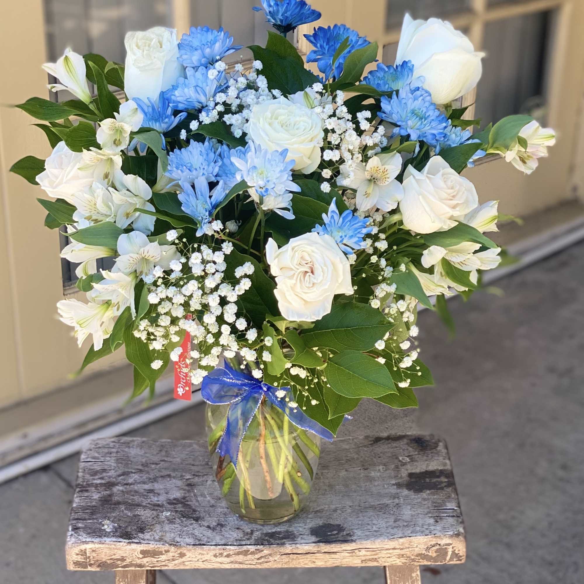 Blue and white bouquet in a glass vase with a ribbon