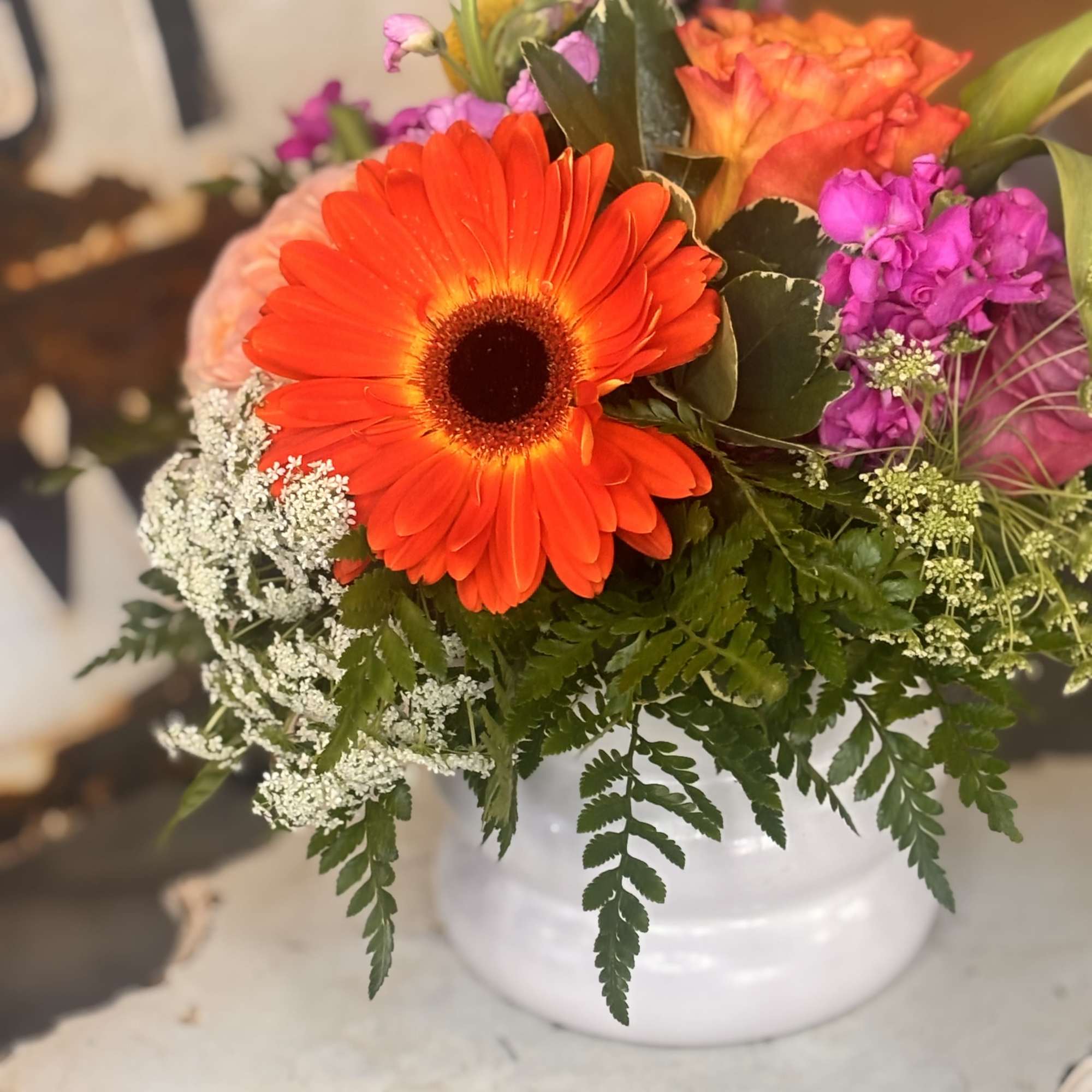 A vivid orange gerbera takes center stage in this cheerful mixed bouquet
