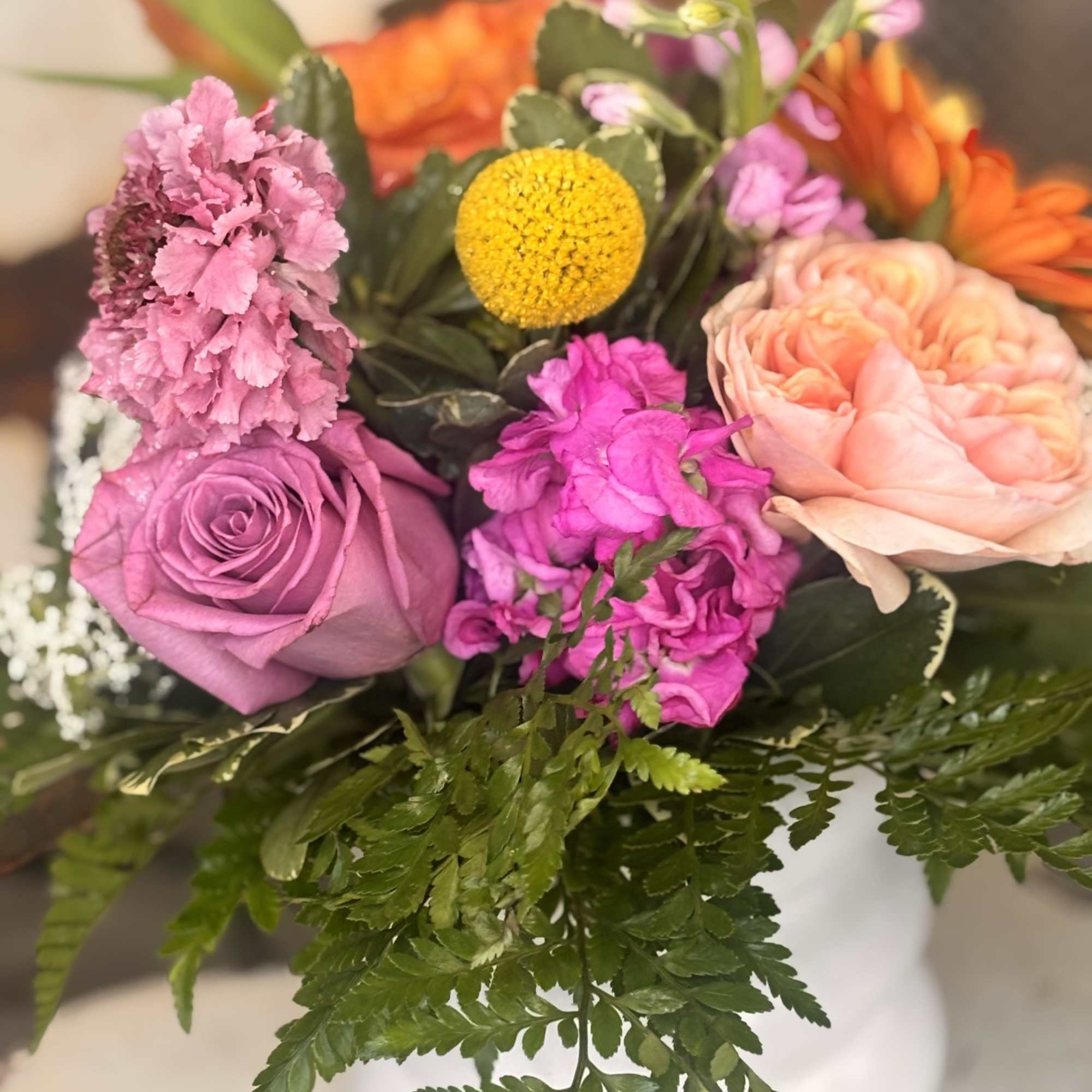 A vivid orange gerbera takes center stage in this cheerful mixed bouquet
