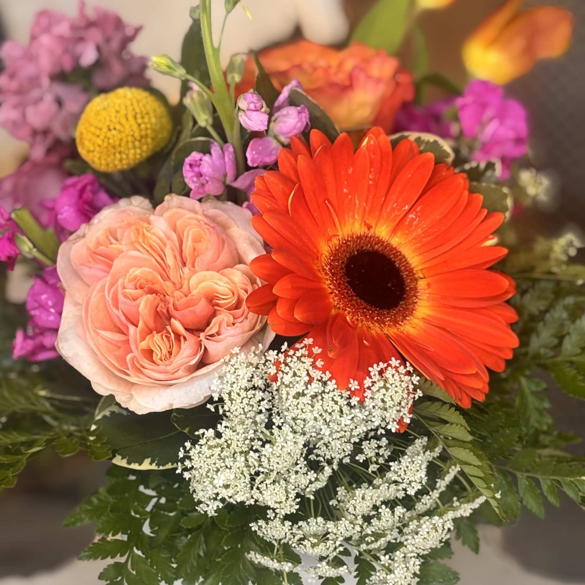 A vivid orange gerbera takes center stage in this cheerful mixed bouquet