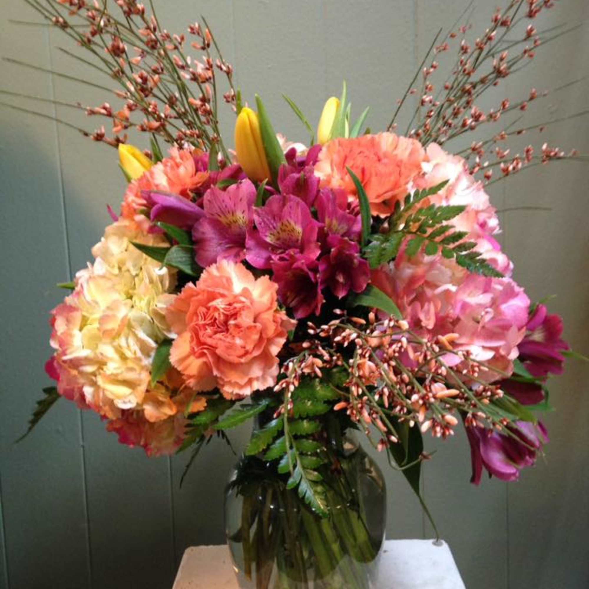 Mixed bouquet in a glass vase with pink, peach, and yellow flowers
