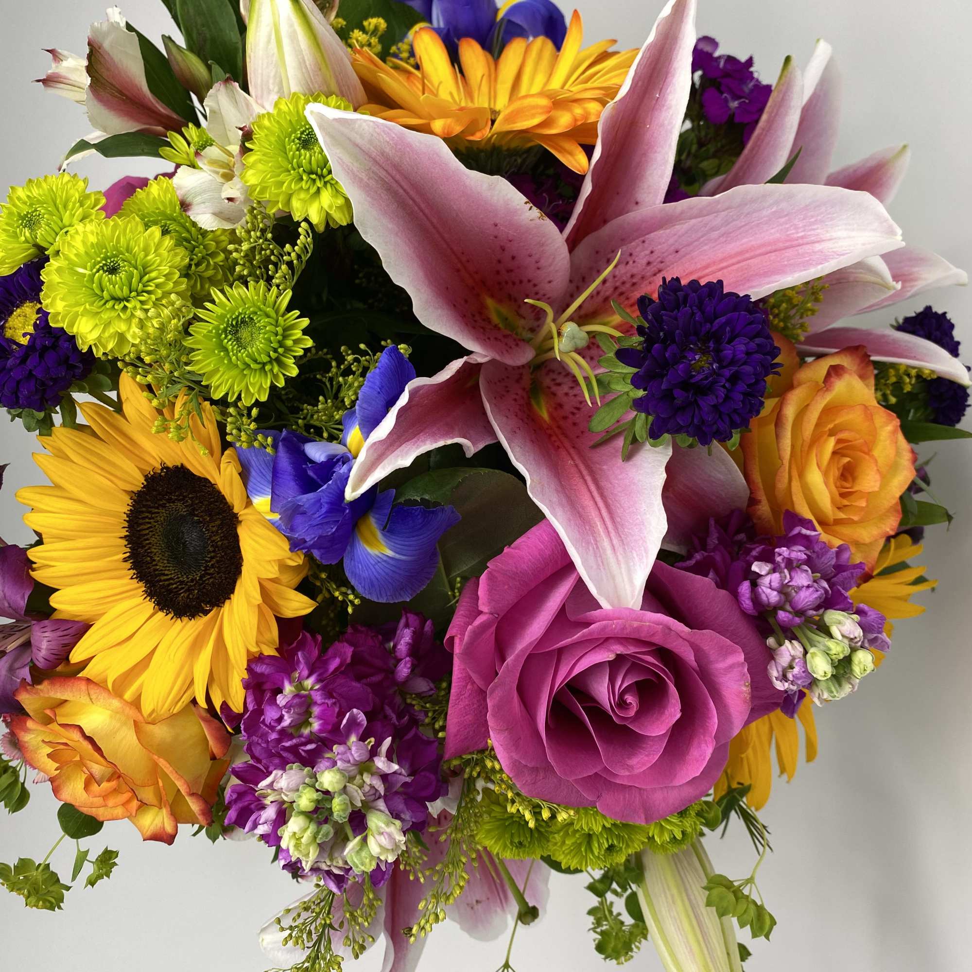 Seasonal bright flowers arranged with fillers and greens into a vase.

NOT CAT