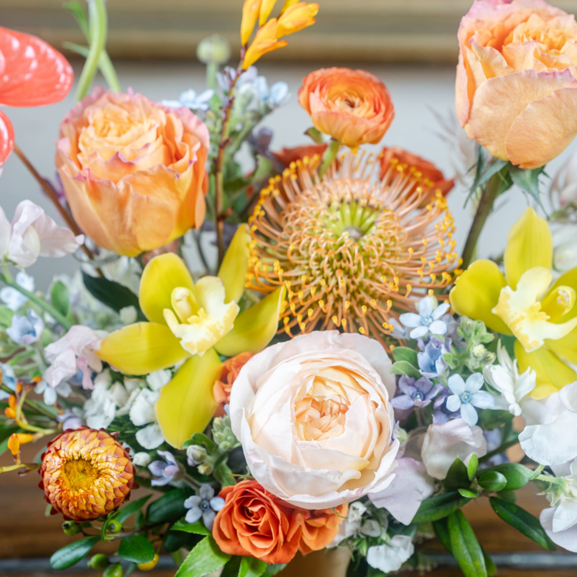 Bouquet of peach and orange flowers with yellow orchids and pale blooms