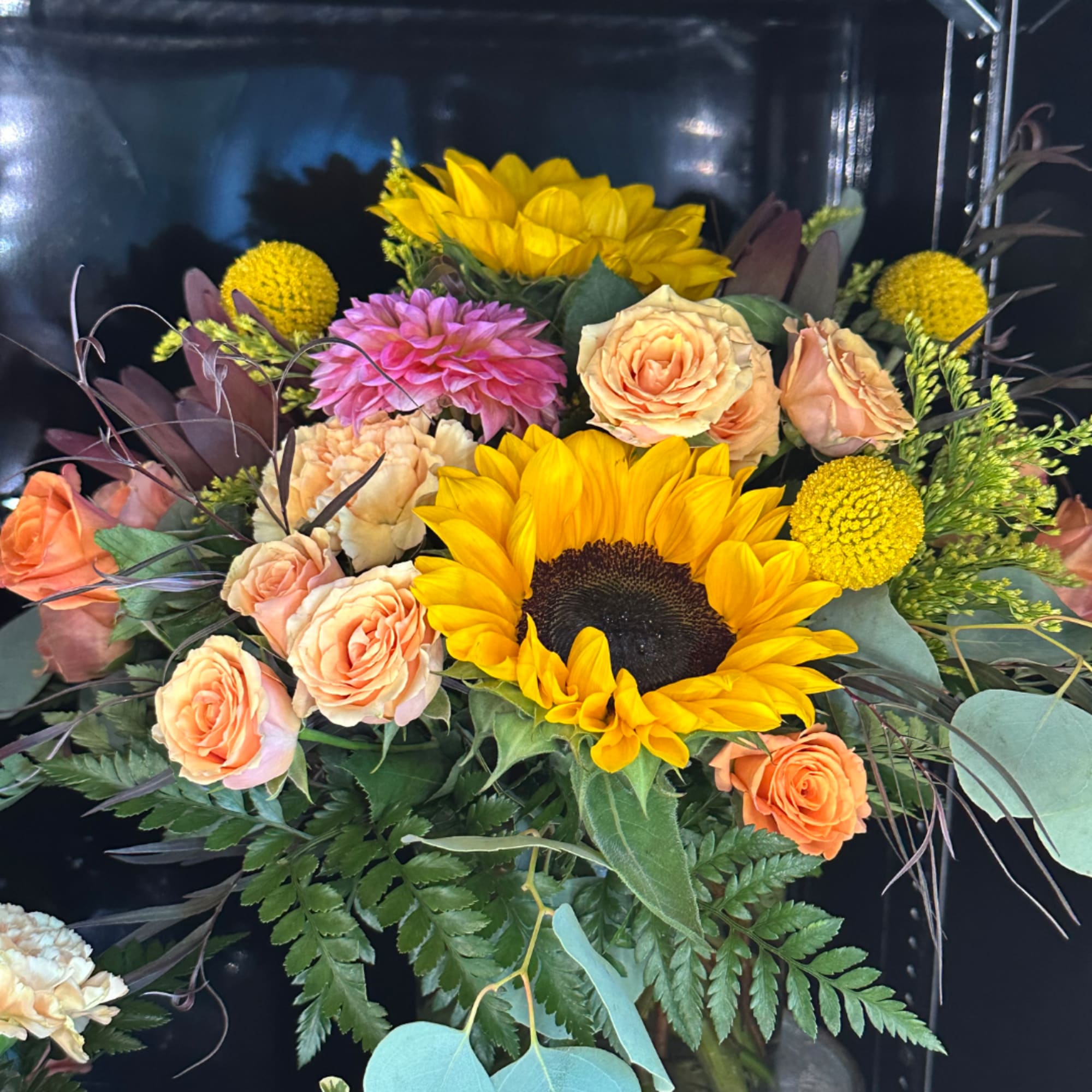 Mixed bouquet with sunflowers, peach roses, and pink blooms